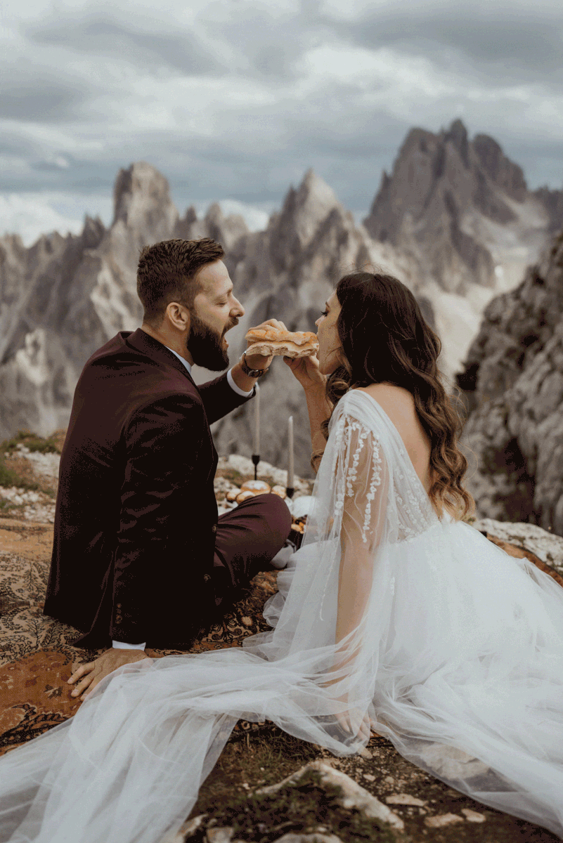Bride feeding groom during Dolomites intimate vow renewal