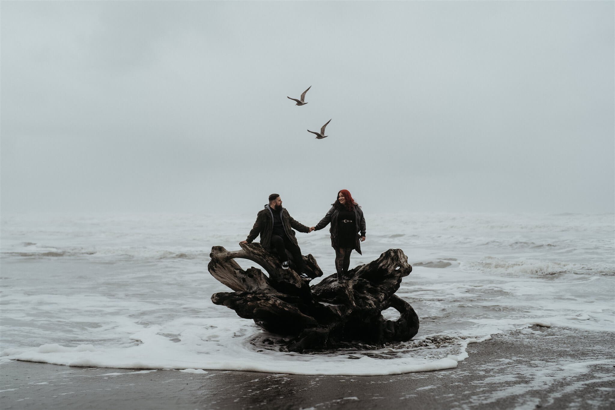 Couple holding hands at Ruby Beach for Halloween engagement session