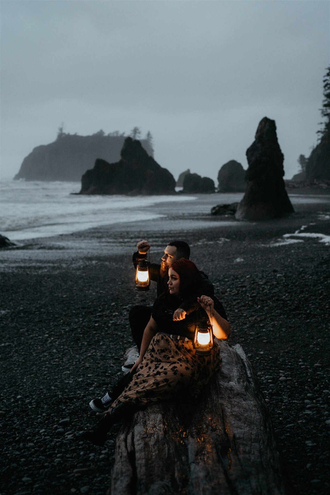 Couple holding lanterns during Halloween engagement photo session at Ruby Beach
