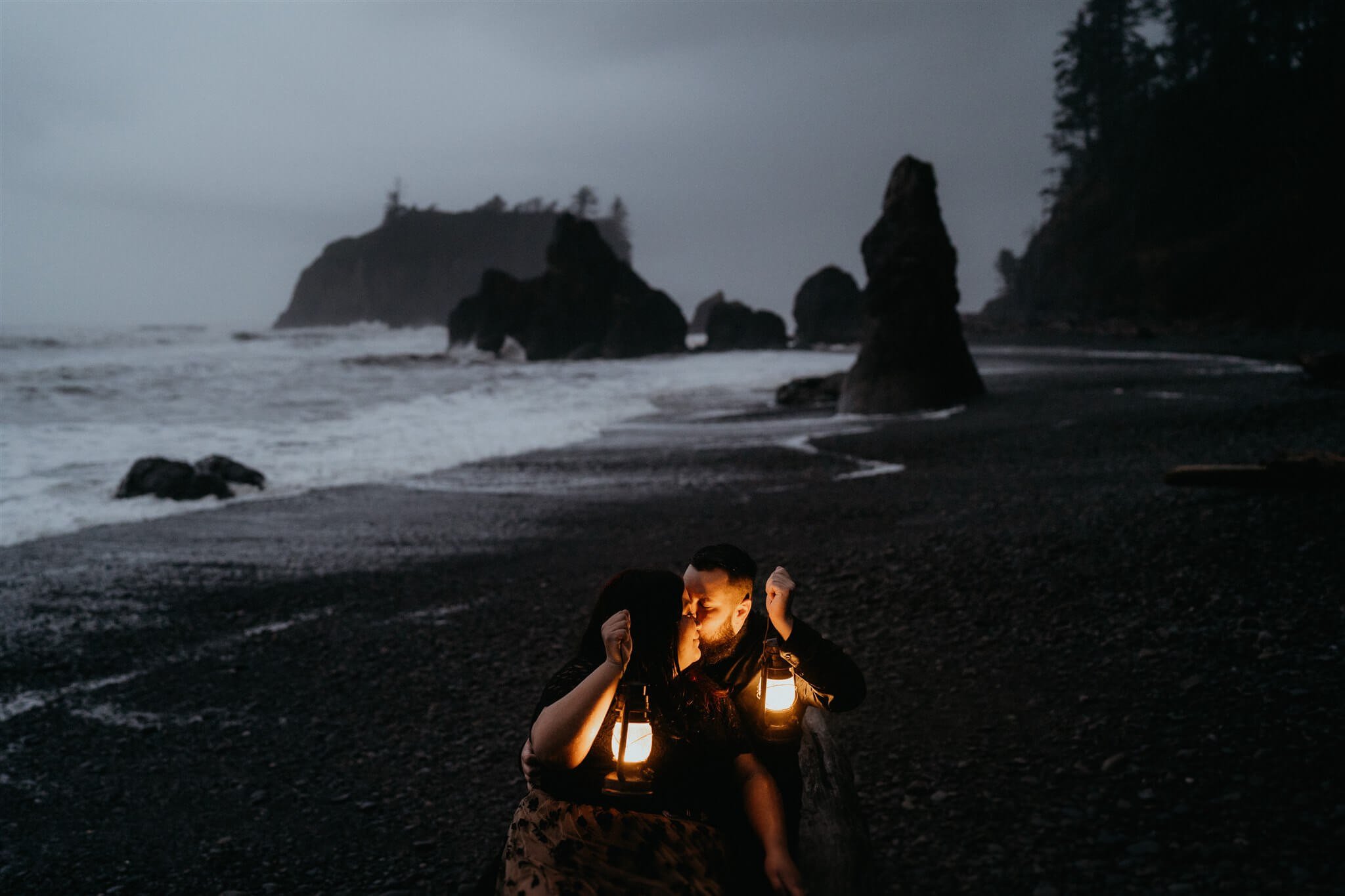 Couple holding lanterns during Halloween engagement photo session at Ruby Beach