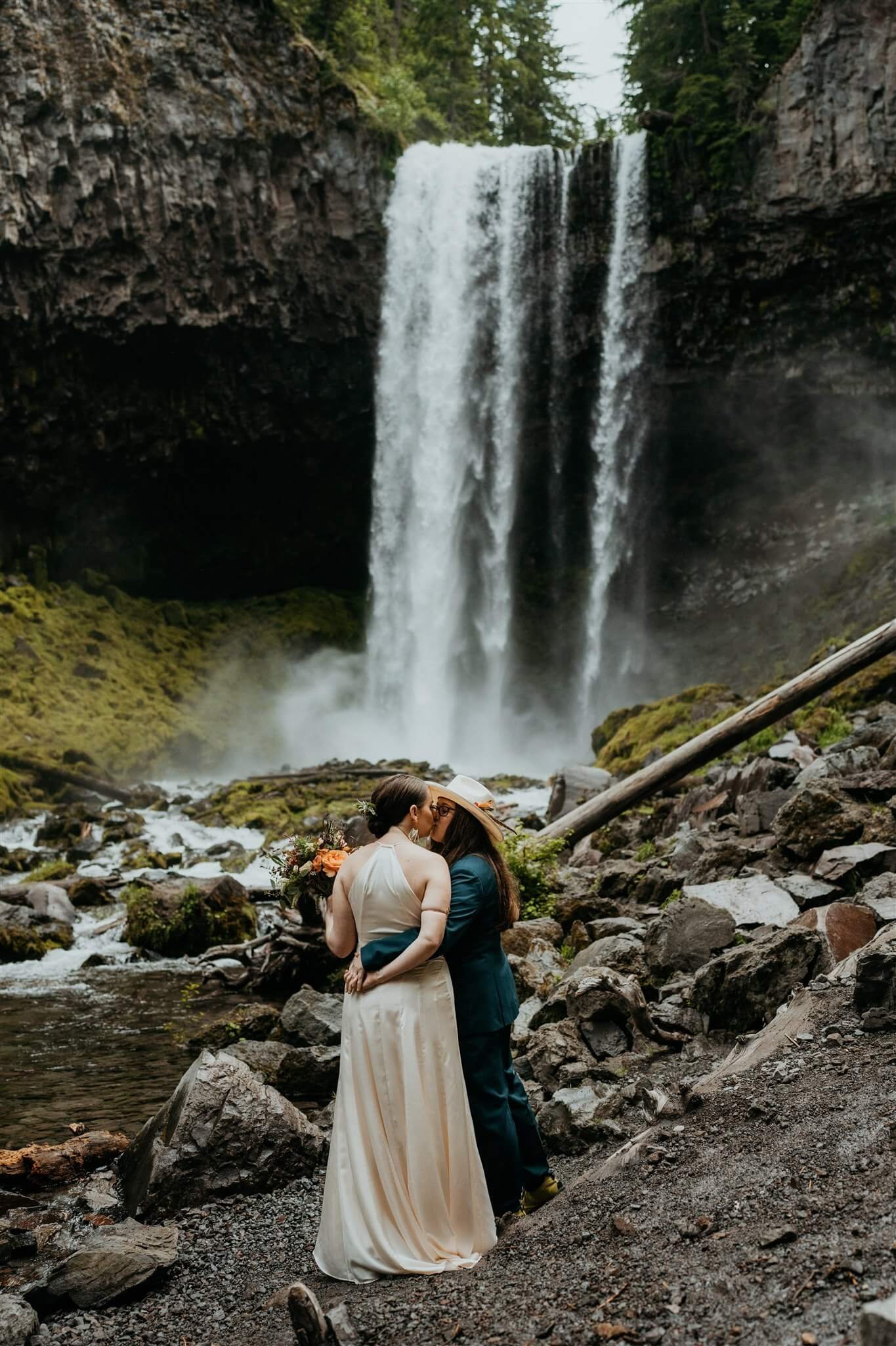Two brides kiss at waterfall elopement in Mt Hood