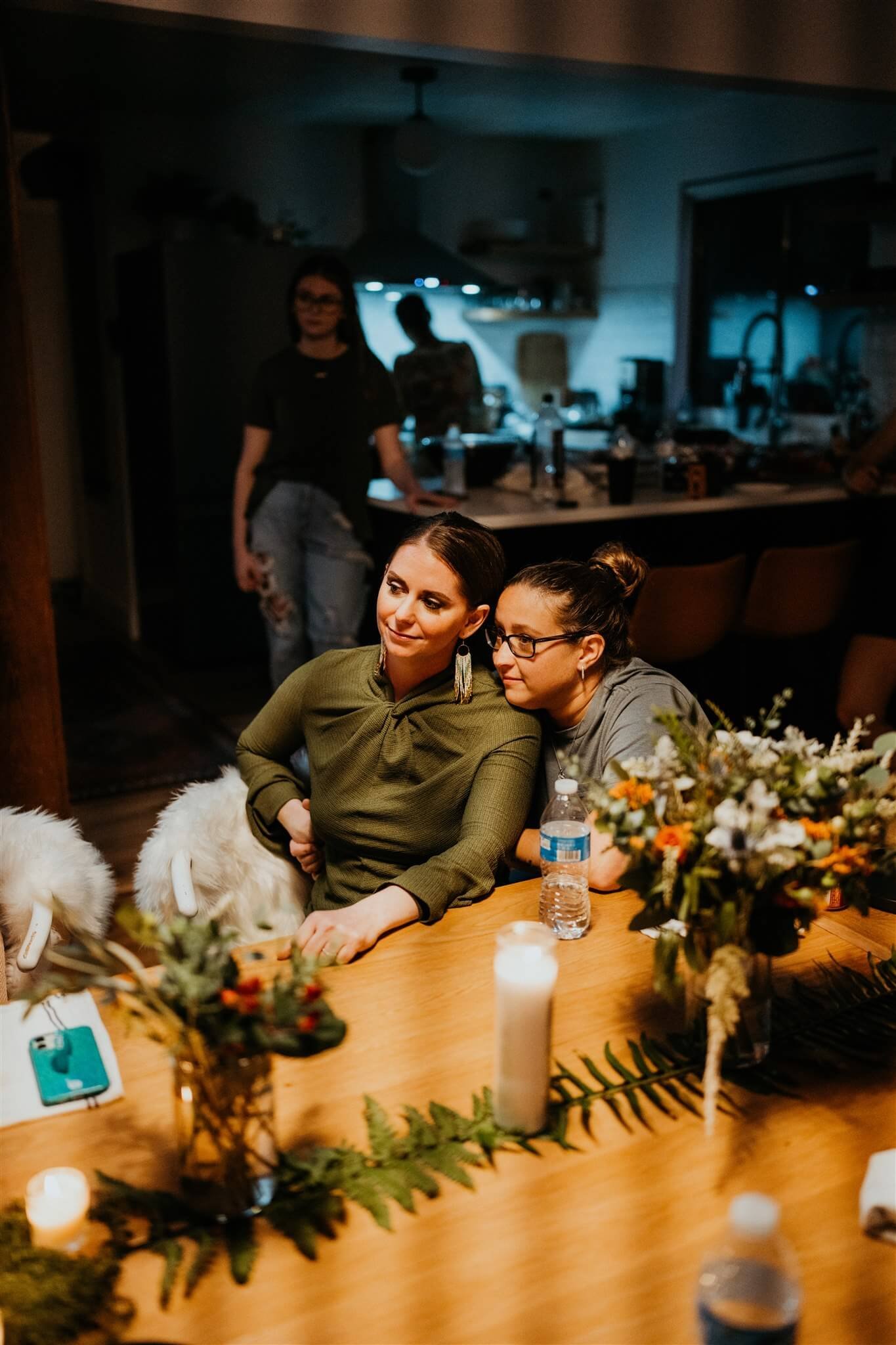 Brides listen to violinist during intimate wedding reception dinner at Airbnb cabin