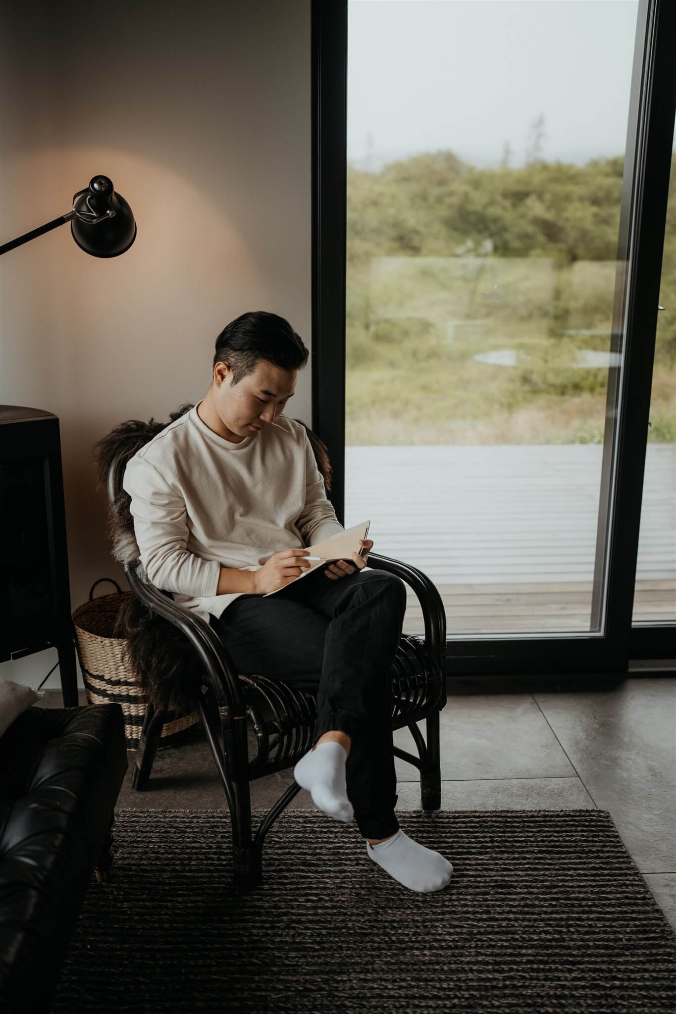 Groom sitting in a chair, writing elopement vows before his elopement in Iceland