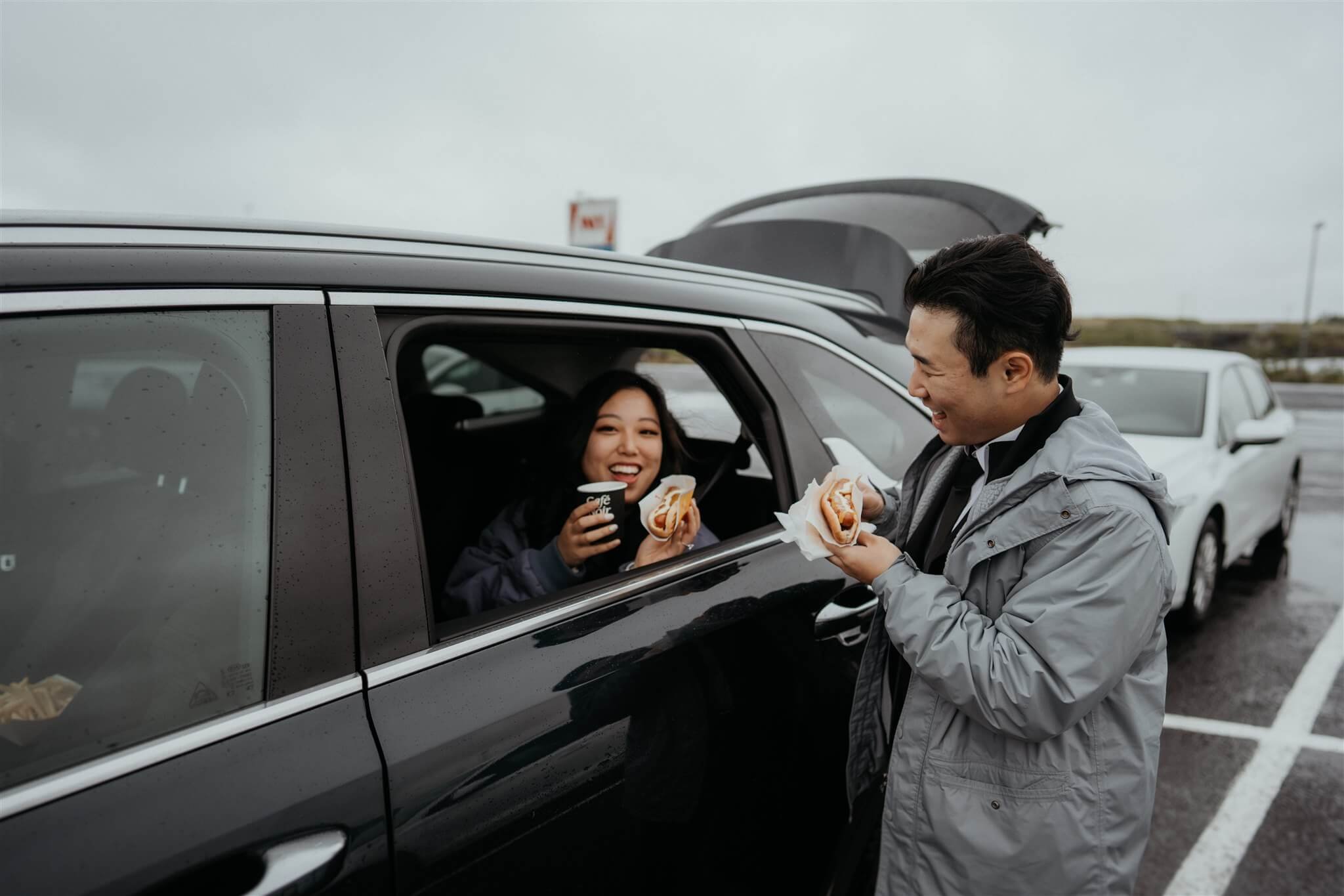 Bride and groom eating hot dogs in the car before eloping in Iceland