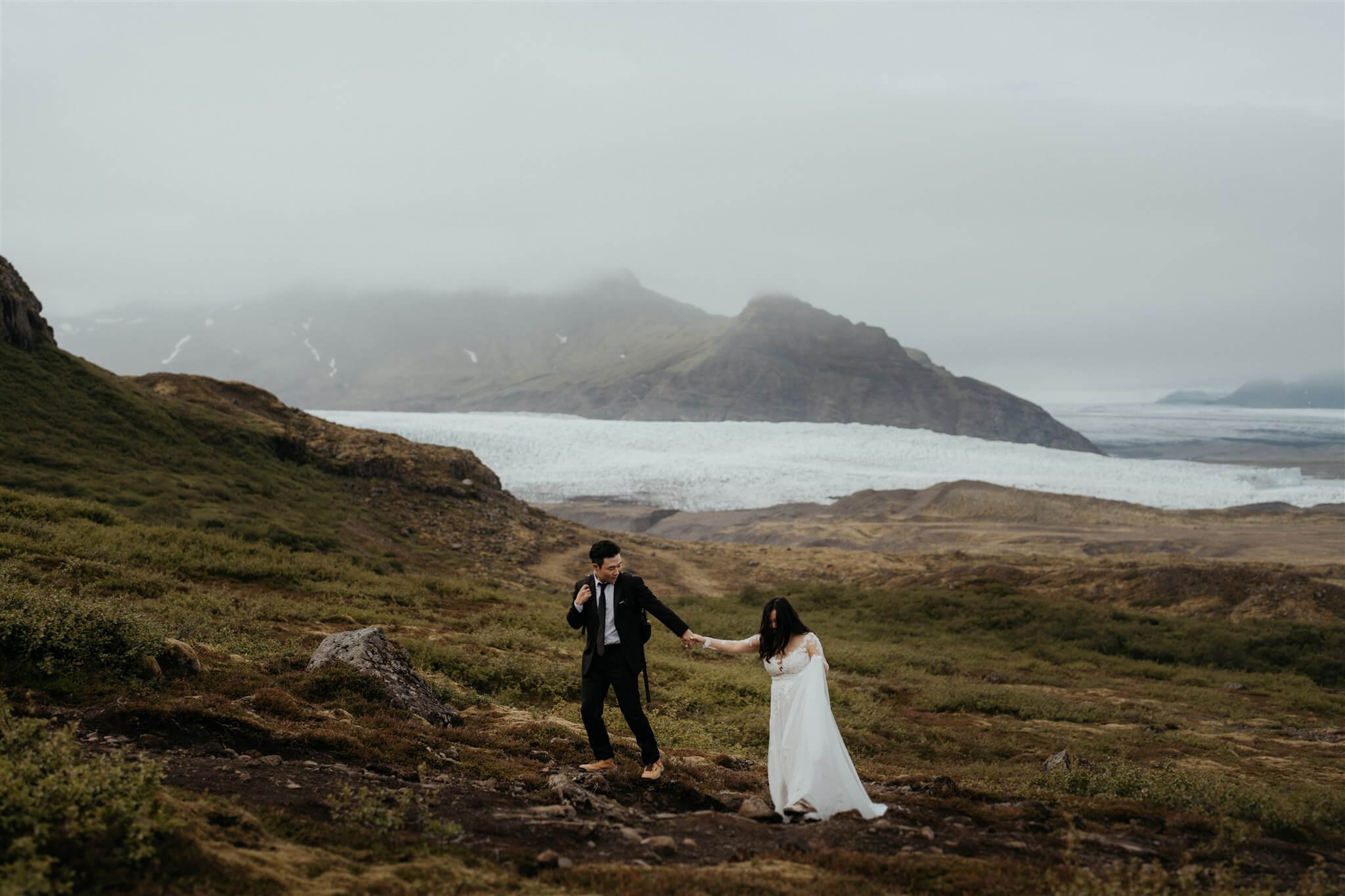 Bride and groom hiking a trail while they elope in Iceland