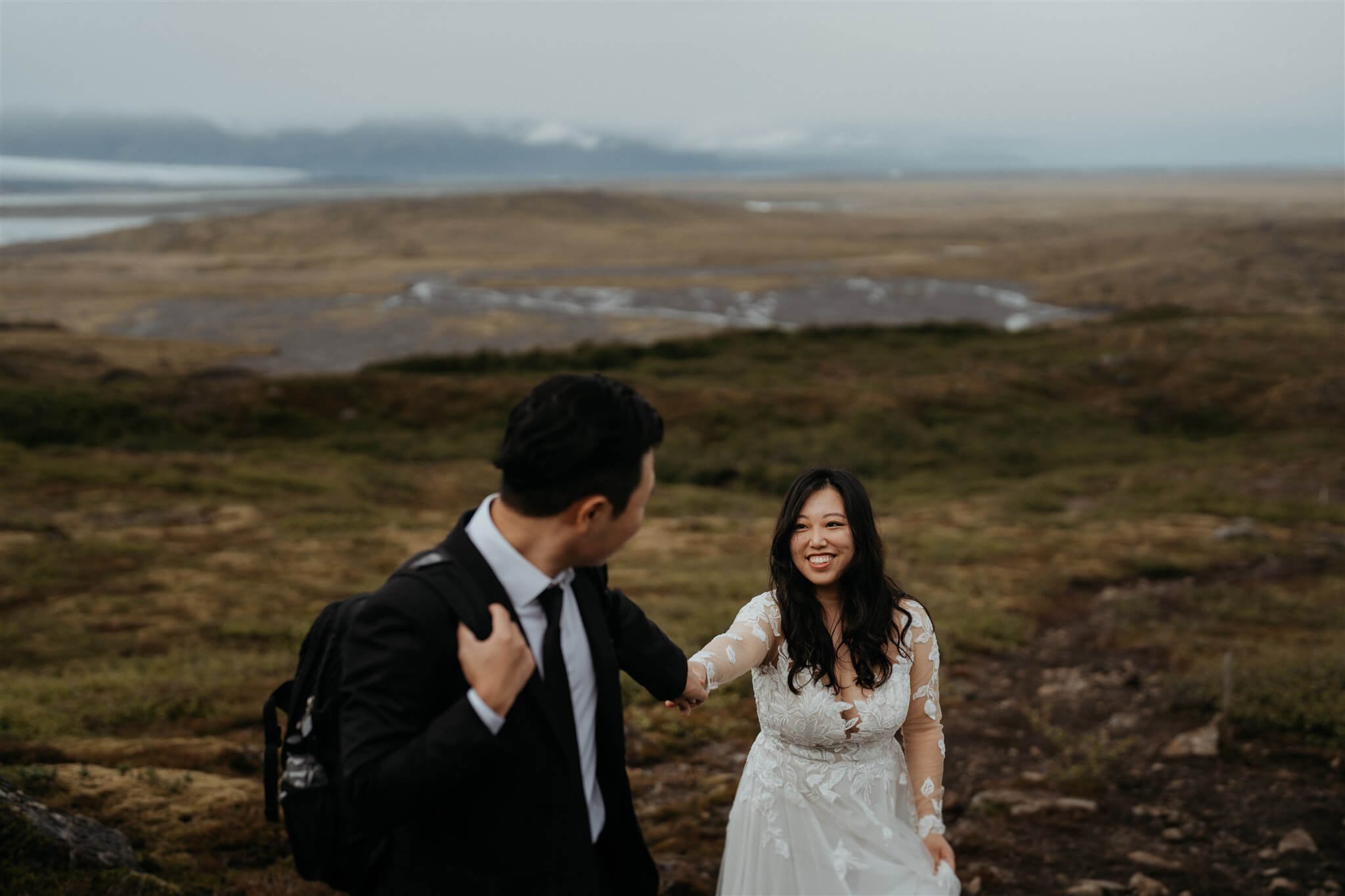 Bride and groom hiking a trail while they elope in Iceland