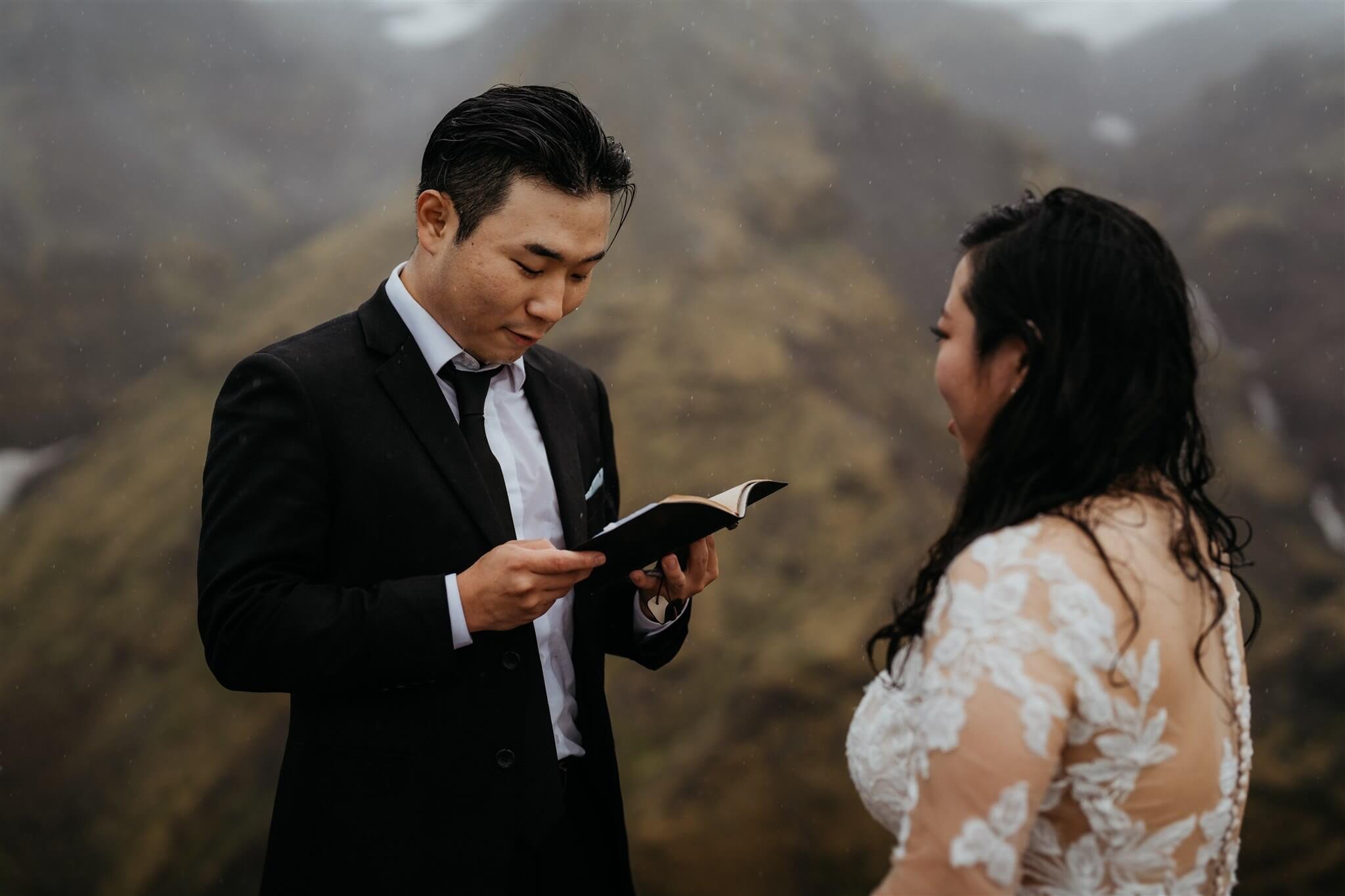 Groom reading handwritten vows while eloping in Iceland