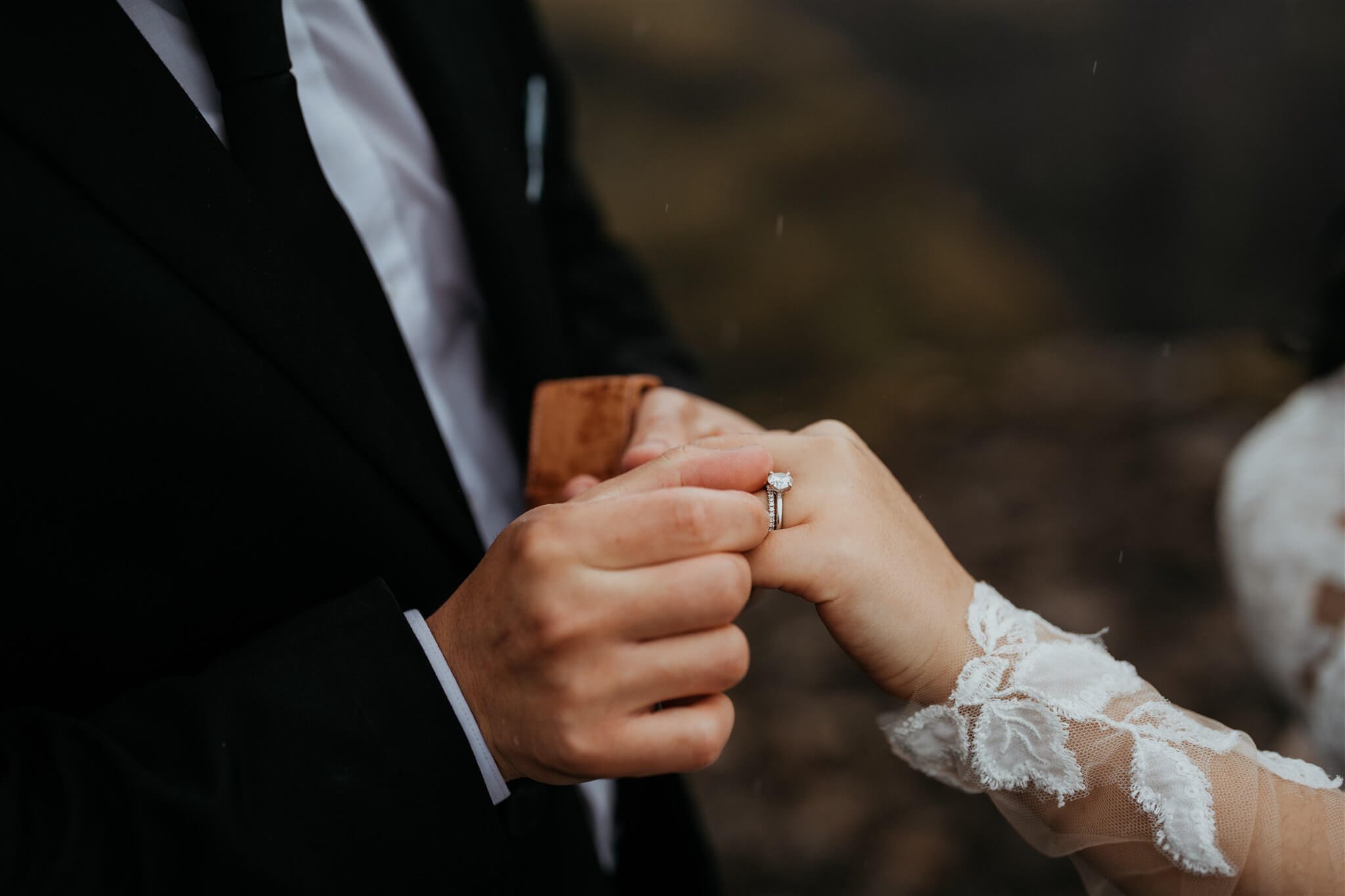 Groom putting ring on bride's hand during elopement in Iceland
