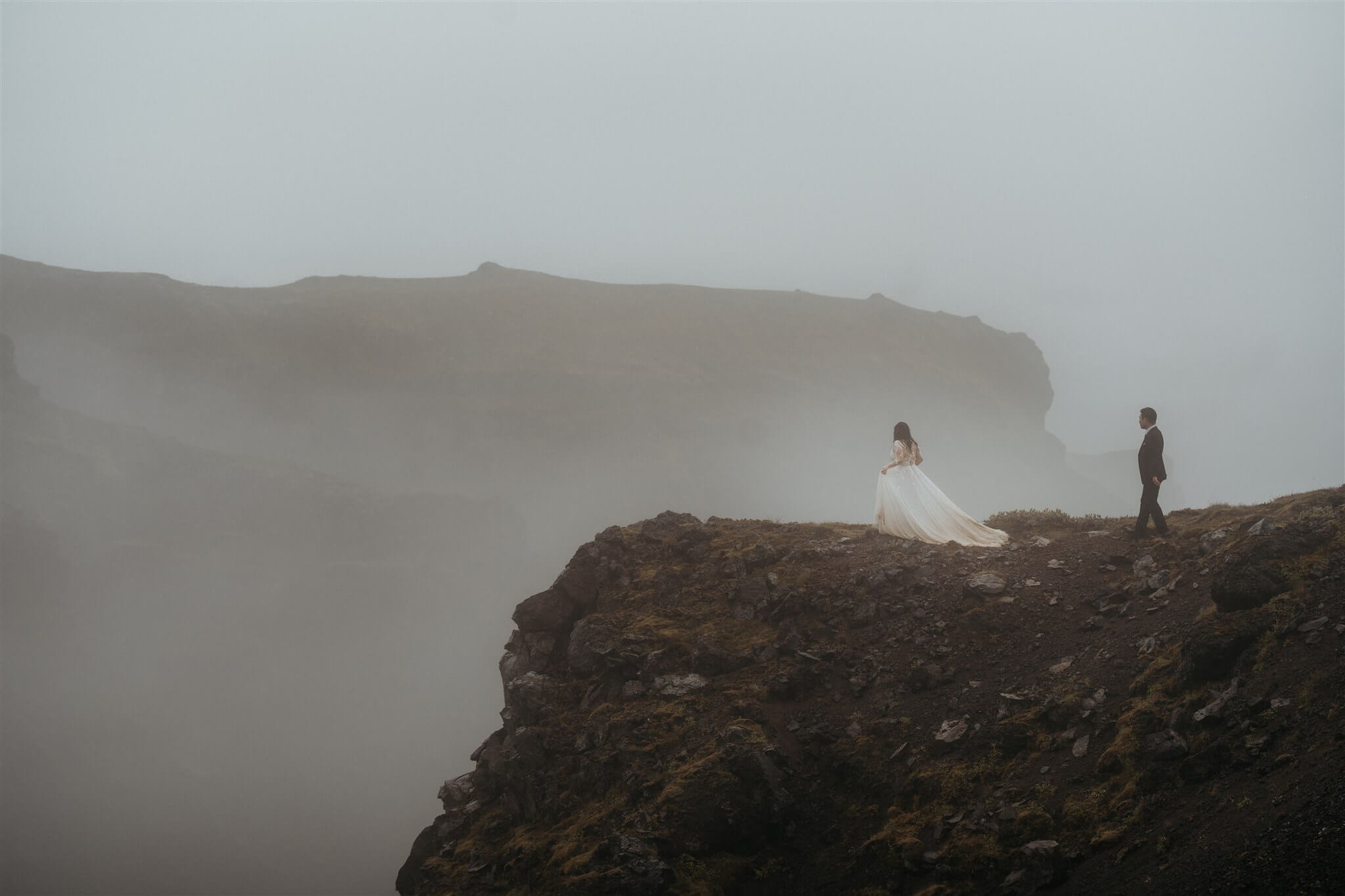 Bride and groom couple portraits on a hill overlooking a canyon at Iceland elopement