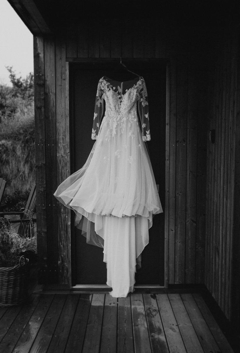 White wedding dress hanging on a hangar and flowing in the wind