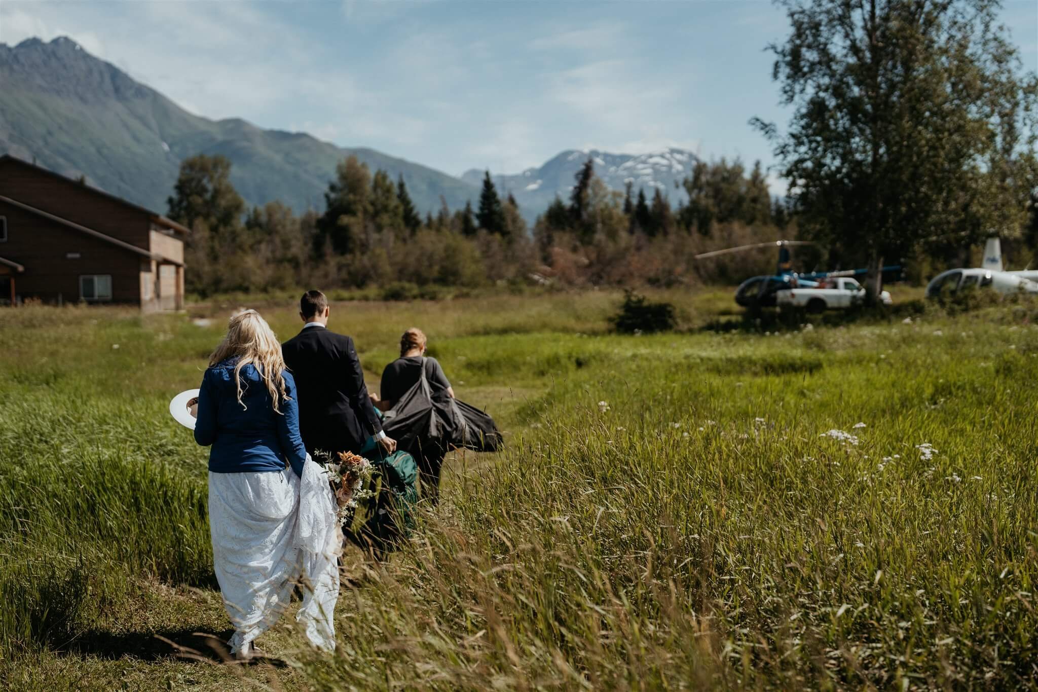 Bride and groom walking to the helicopter for their glacier elopement in Alaska