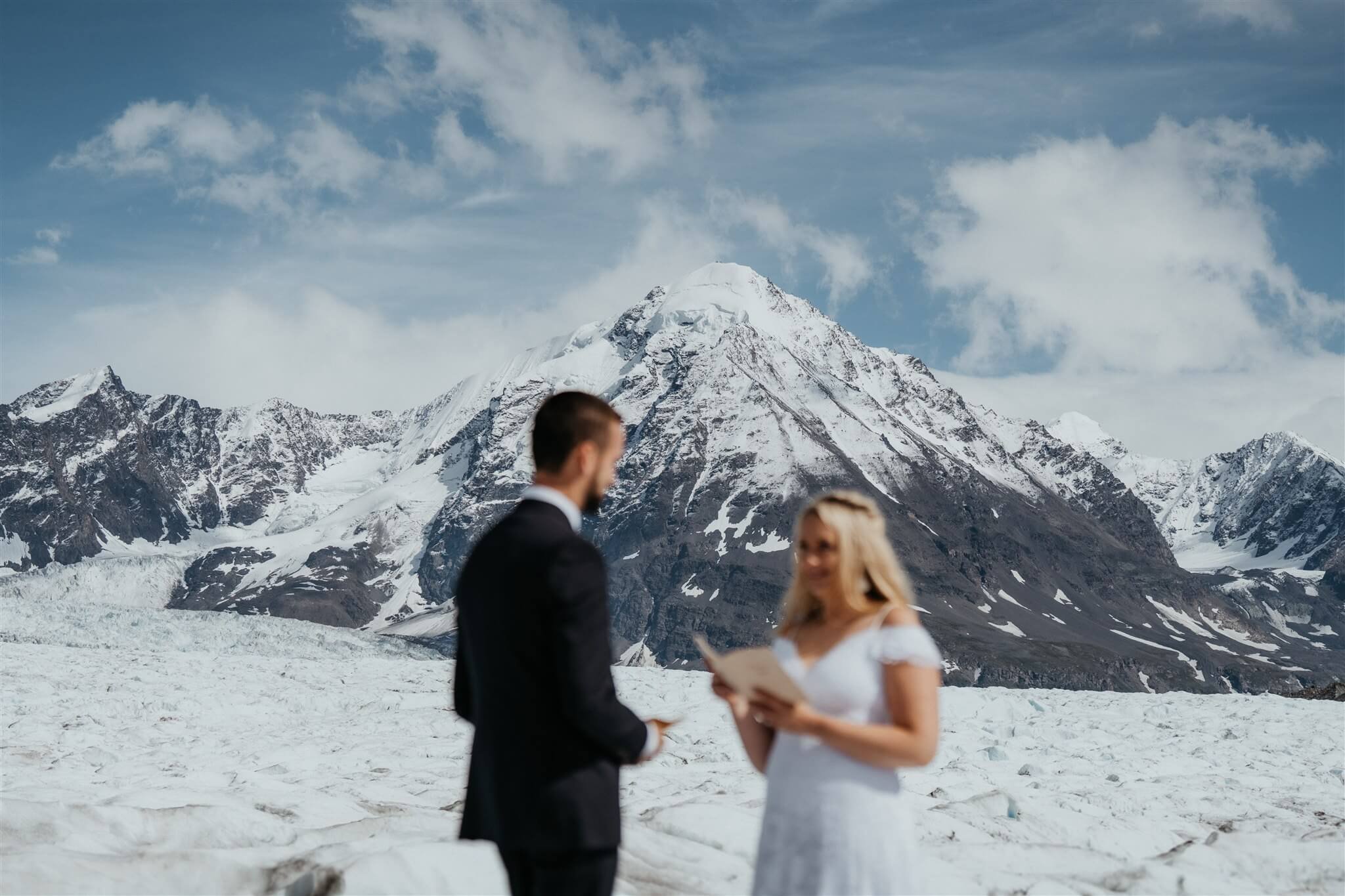 Bride and groom exchange vows during outdoor elopement ceremony on an Alaskan glacier