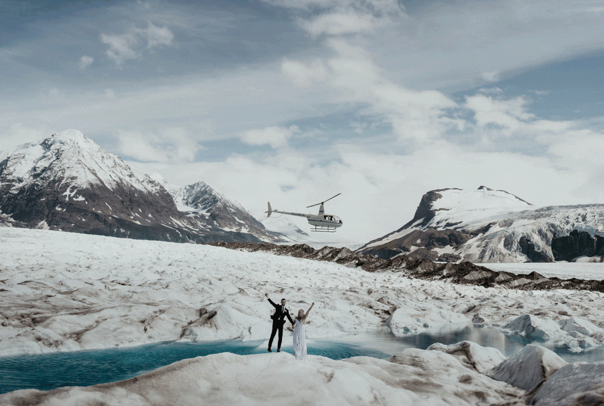 Bride and groom celebrate during helicopter elopement on an Alaskan glacier