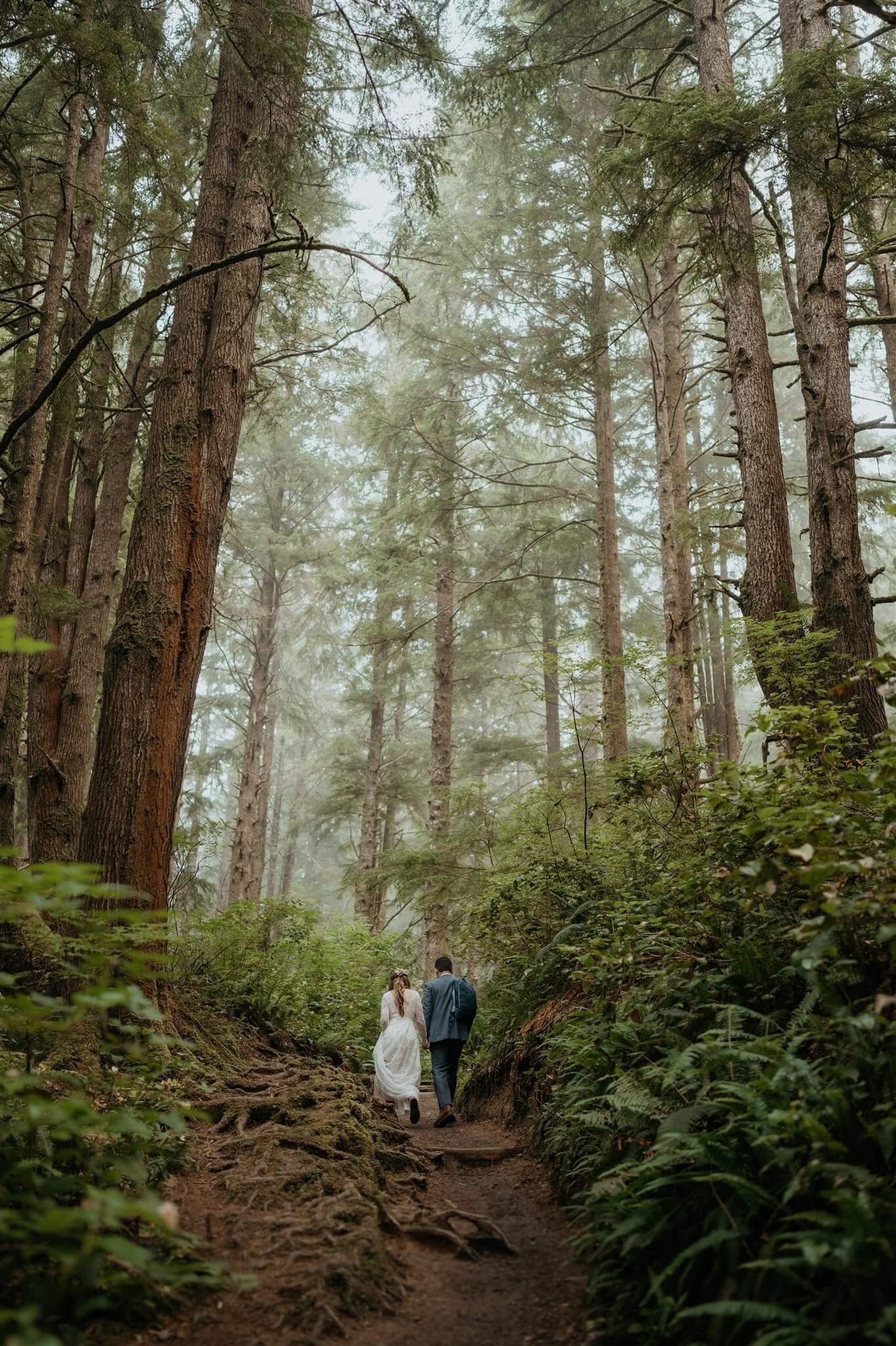 Bride and groom hiking through the forest at Olympic National Park elopement