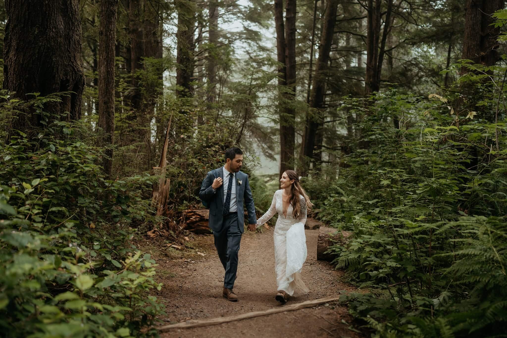 Bride and groom hiking through the forest at Olympic National Park elopement