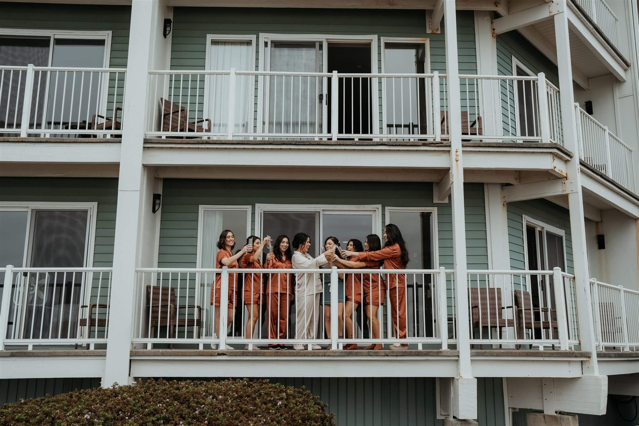 bridal party giving a toast on the balcony of the hotel