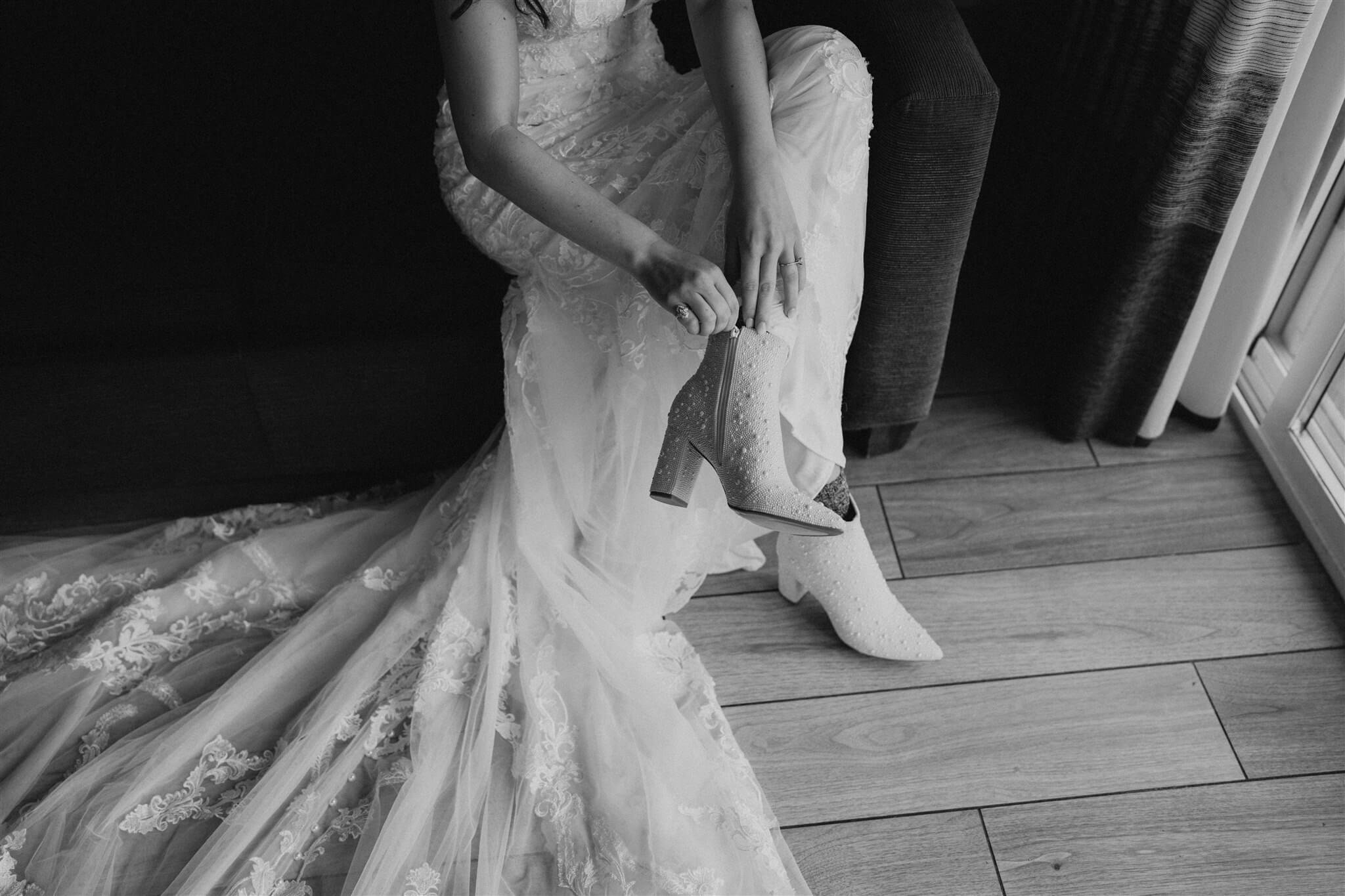 bride putting on shoes at flower filled wedding in Oregon