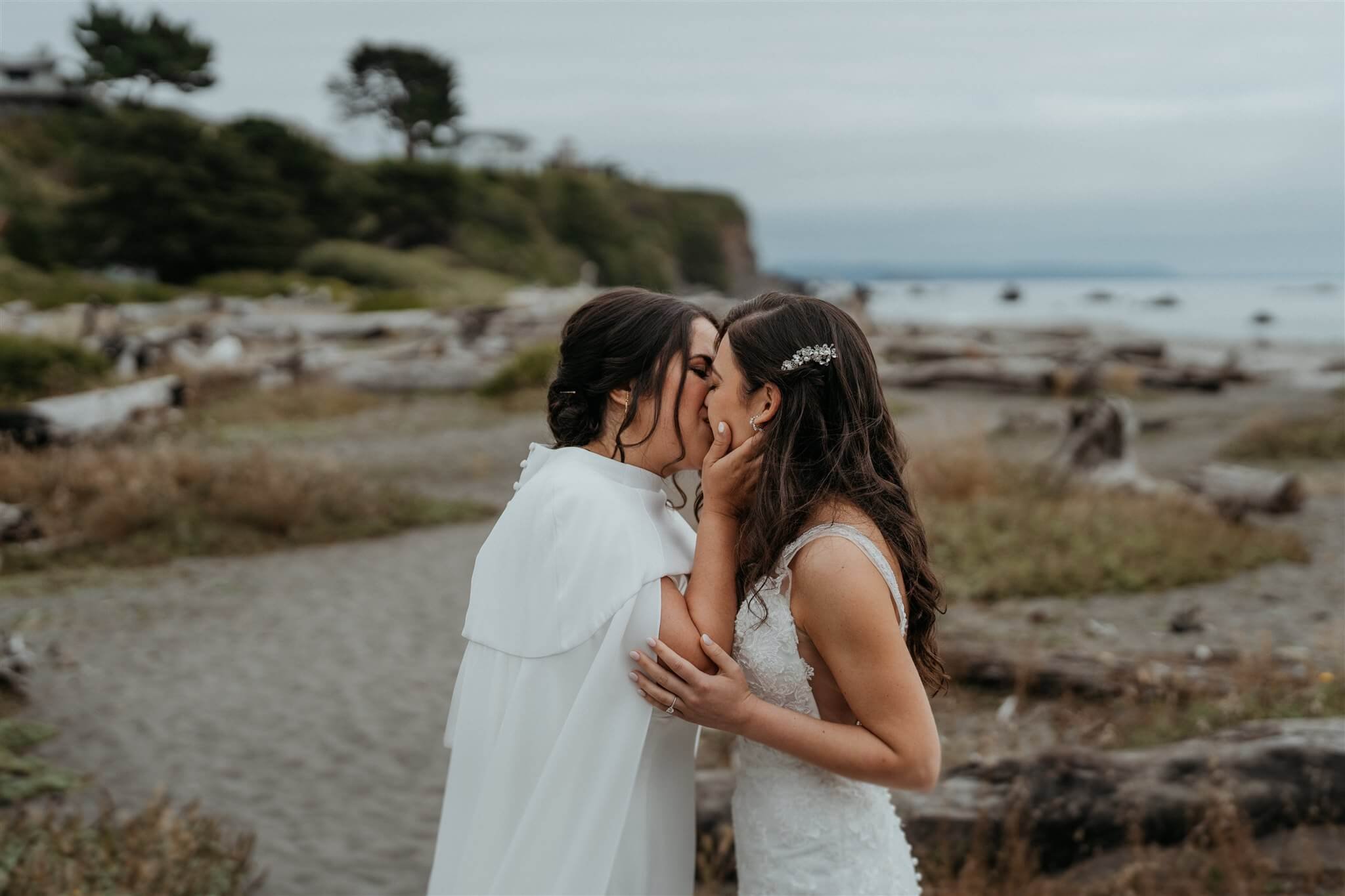 brides kiss after first look on the beach