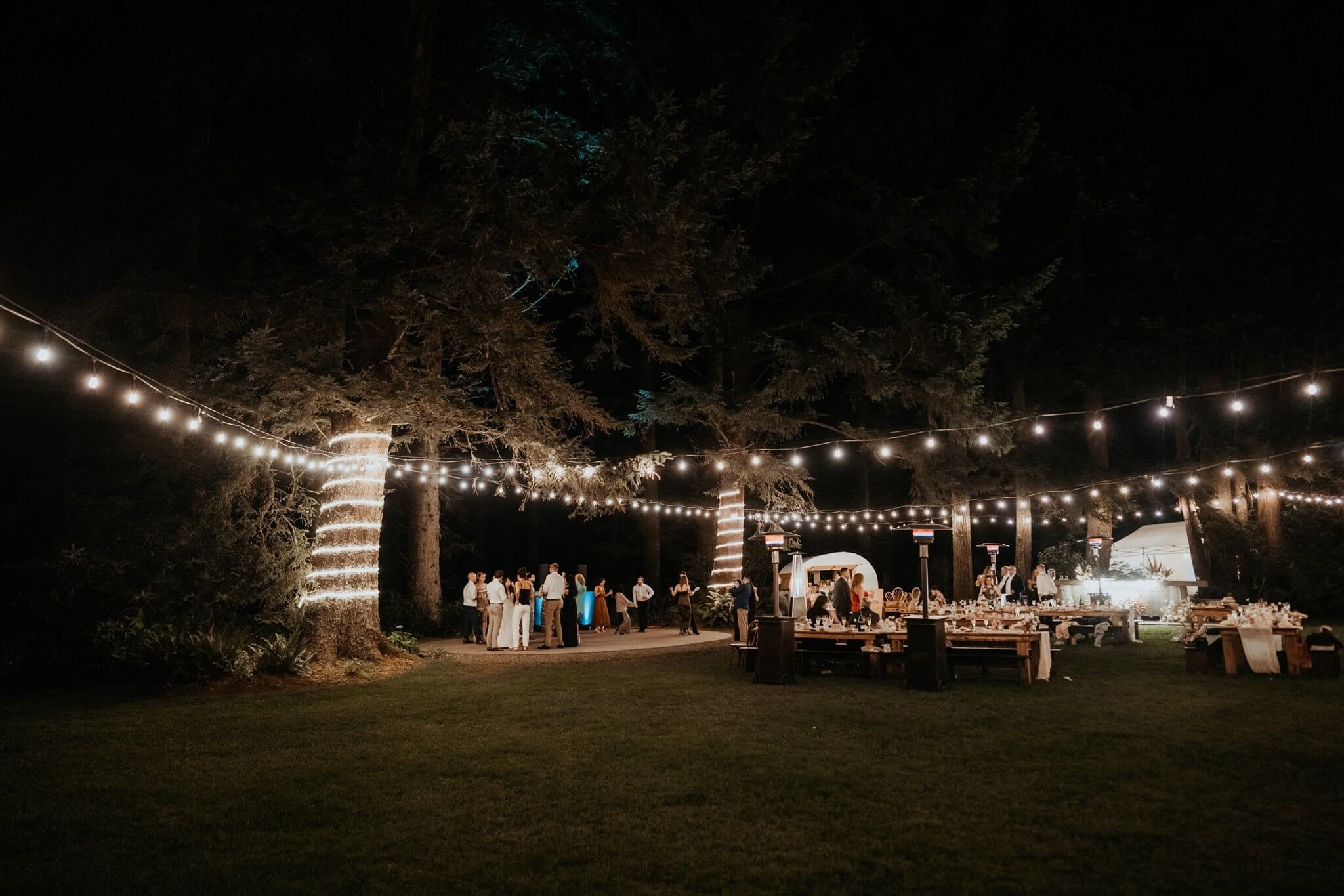 Nighttime outdoor wedding reception with string lights