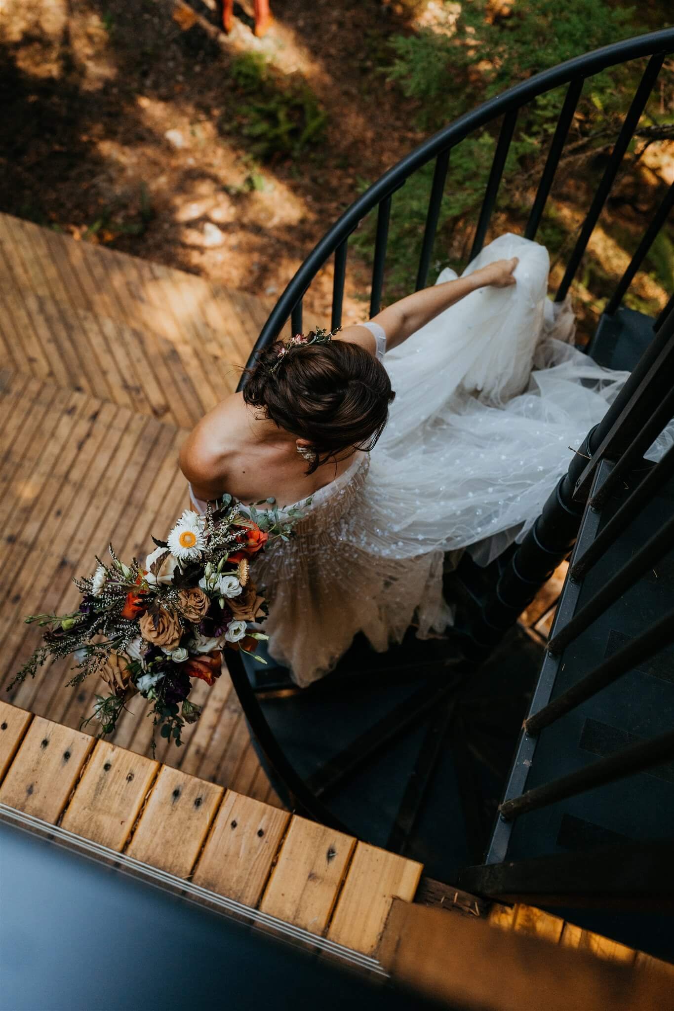 Bride walking down the stairs of cabin for first look in the forest 