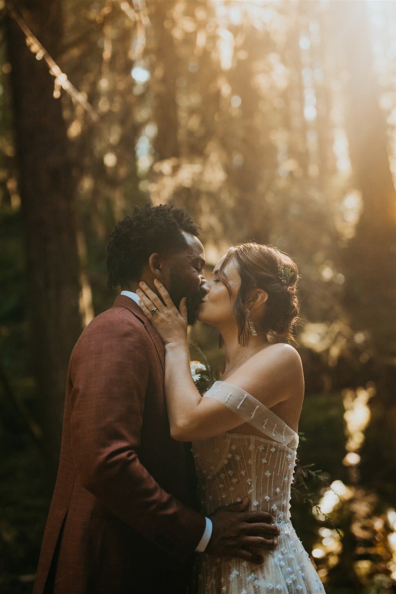 Bride and groom kiss after first look in the forest 