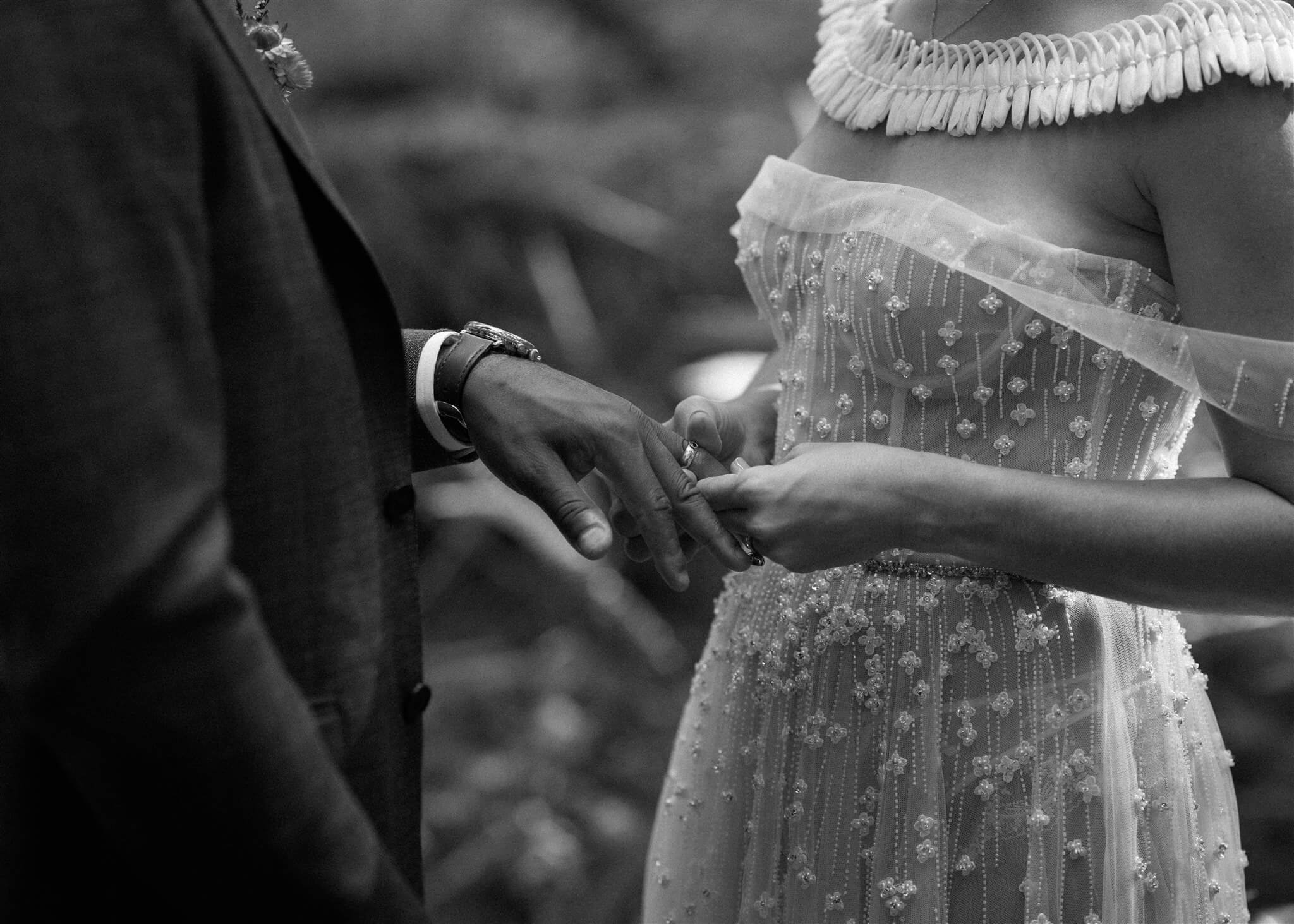 Bride and groom hold hands during elopement ceremony in the forest 