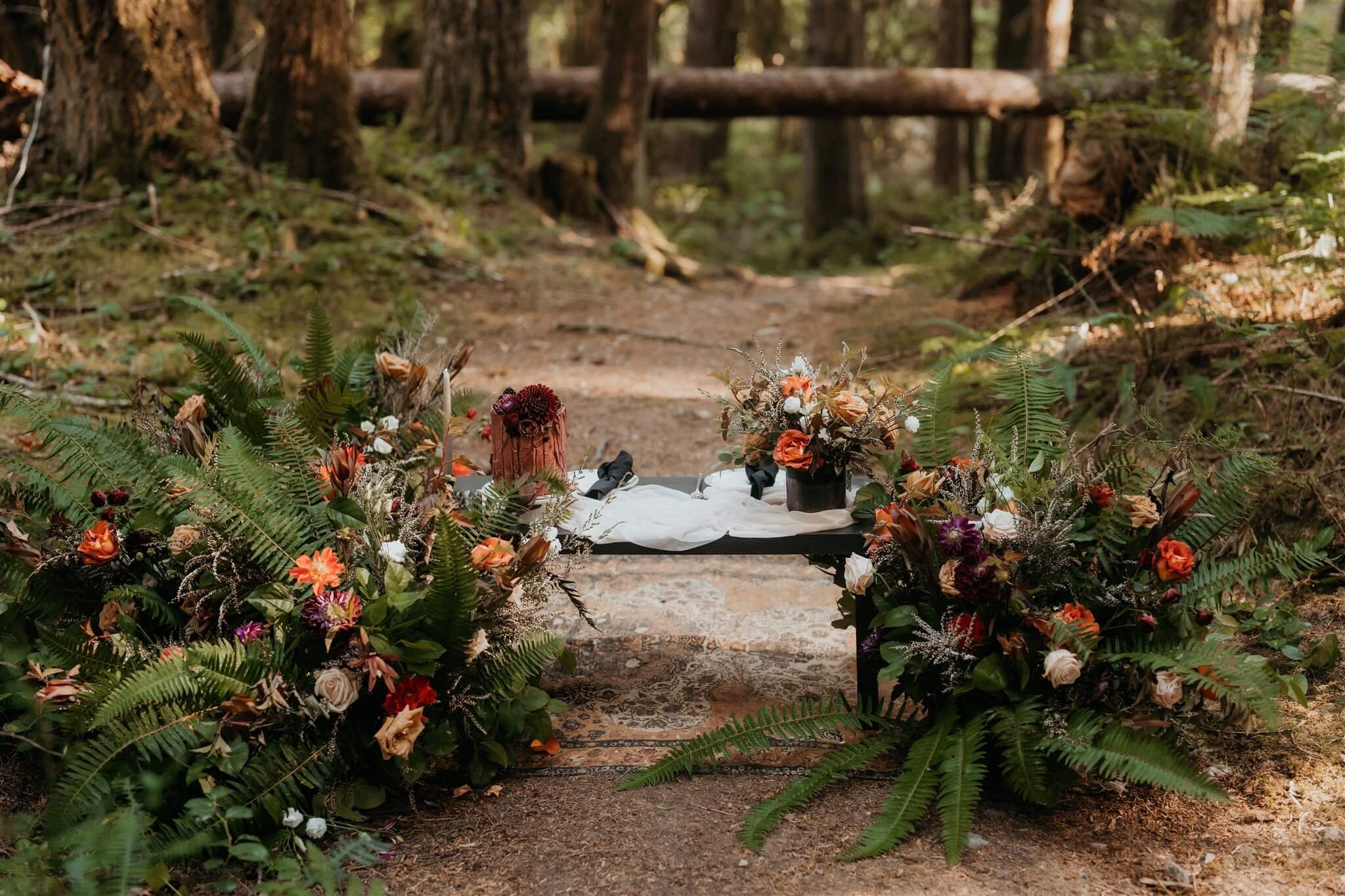 Maroon and white cake table in the woods