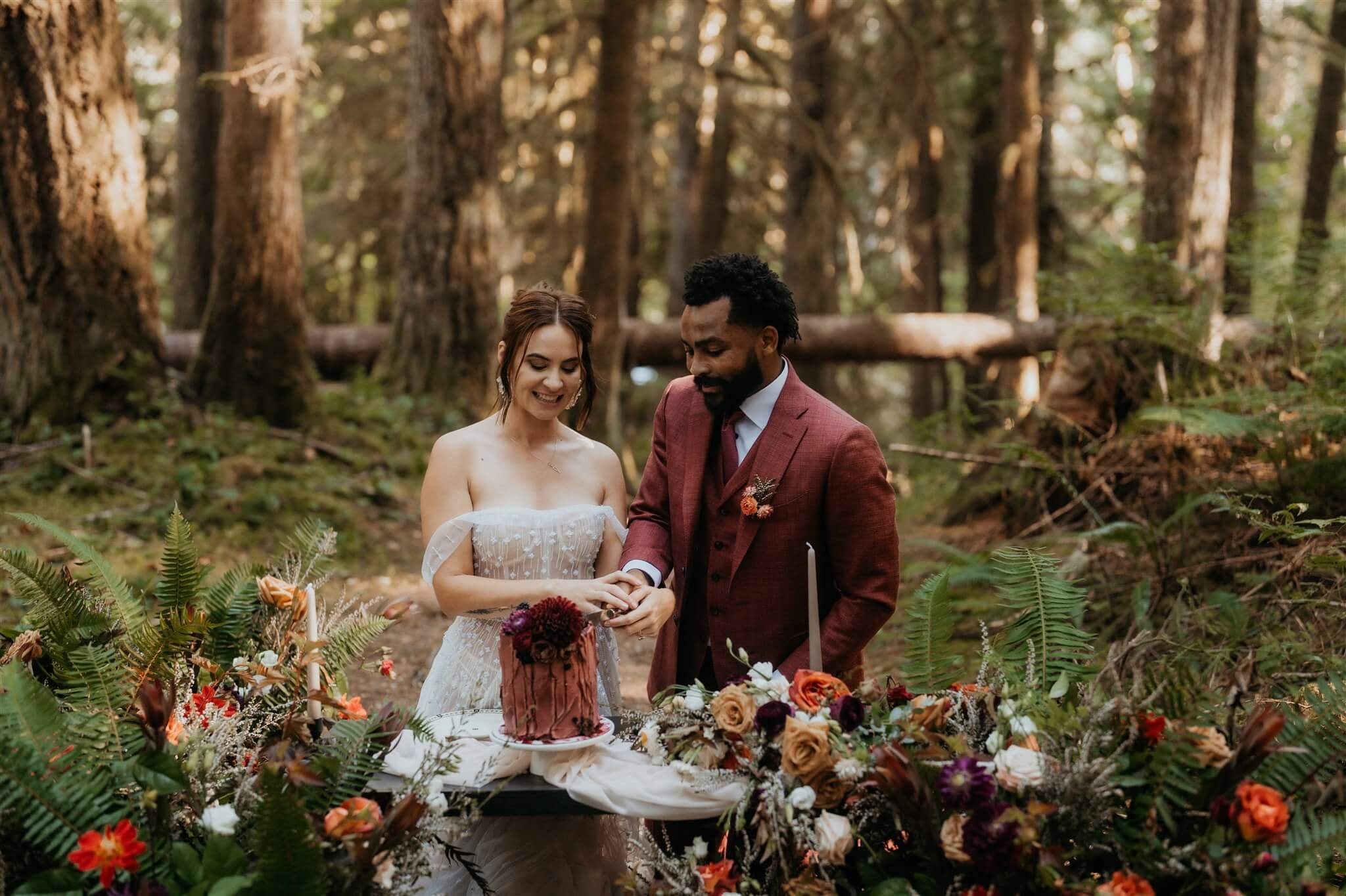 Bride and groom cut cake in the woods after their forest elopement ceremony