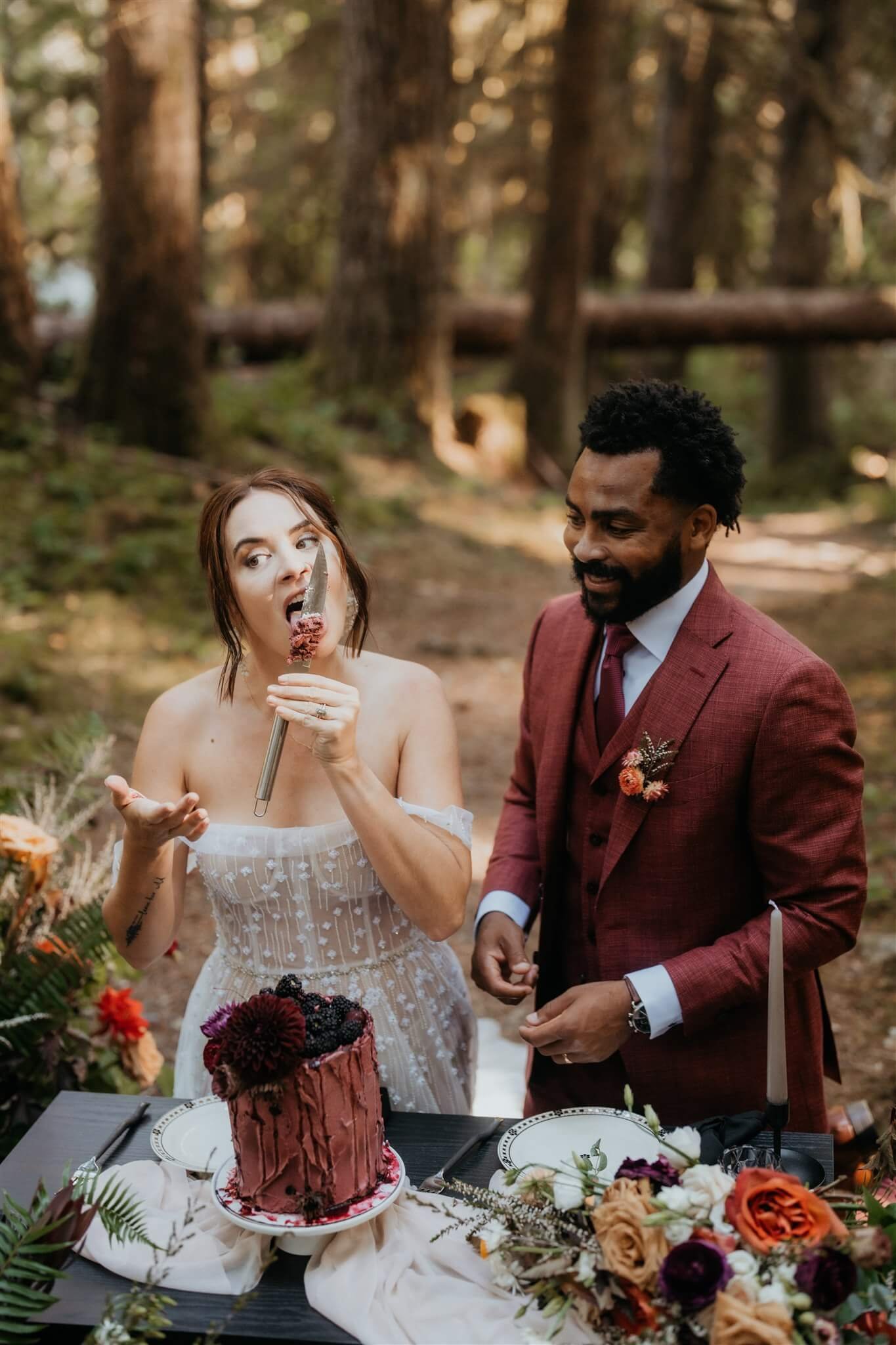 Bride and groom cut cake in the woods after their forest elopement ceremony