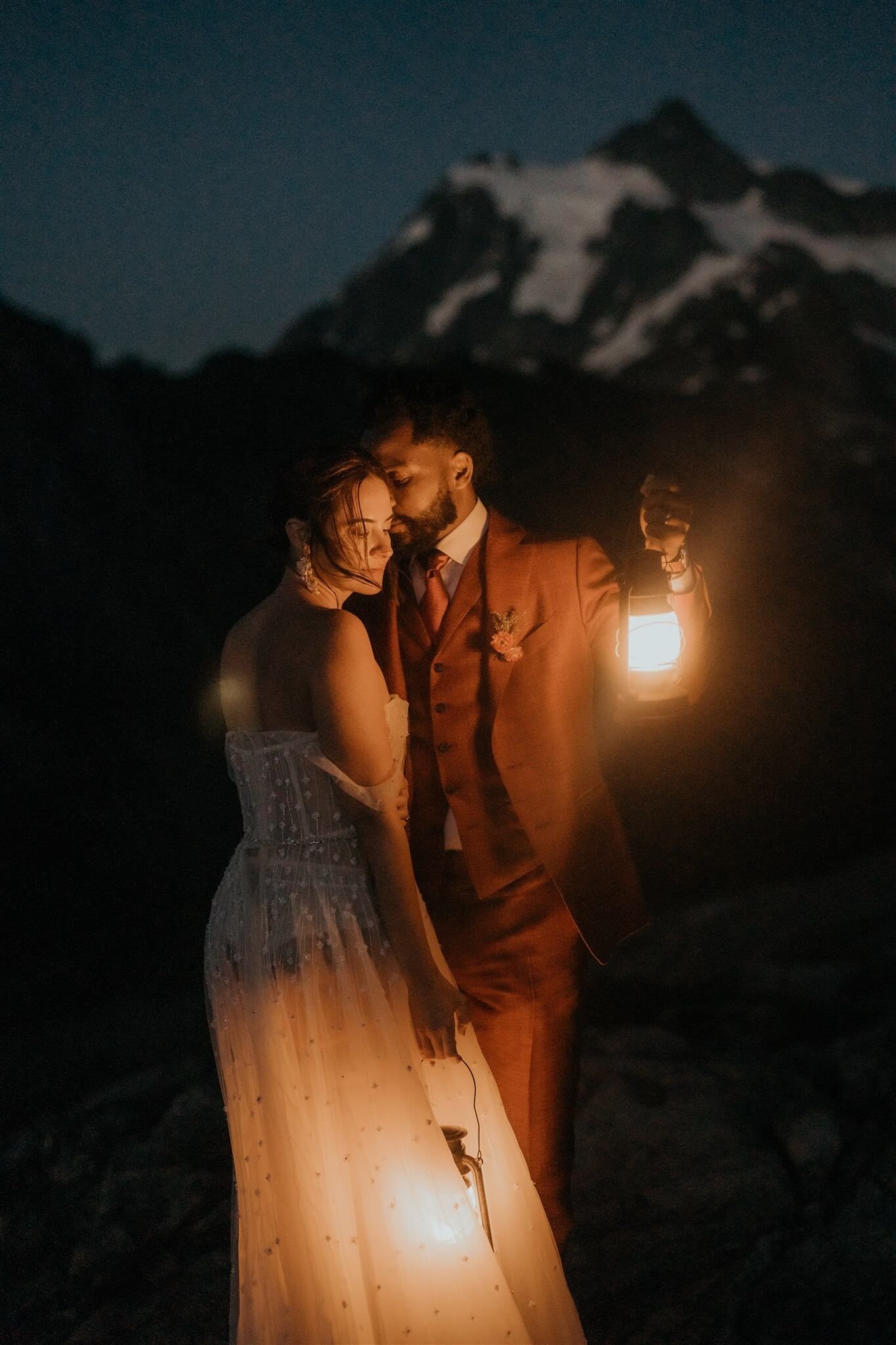Blue hour portraits of bride and groom holding lanterns at their mountain elopement in the North Cascades