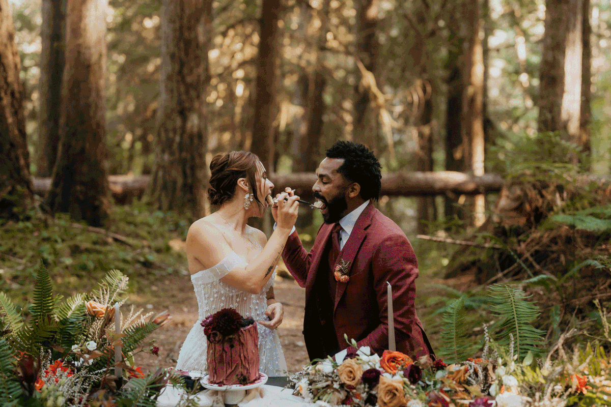 Bride and groom cut cake in the woods after their forest elopement ceremony