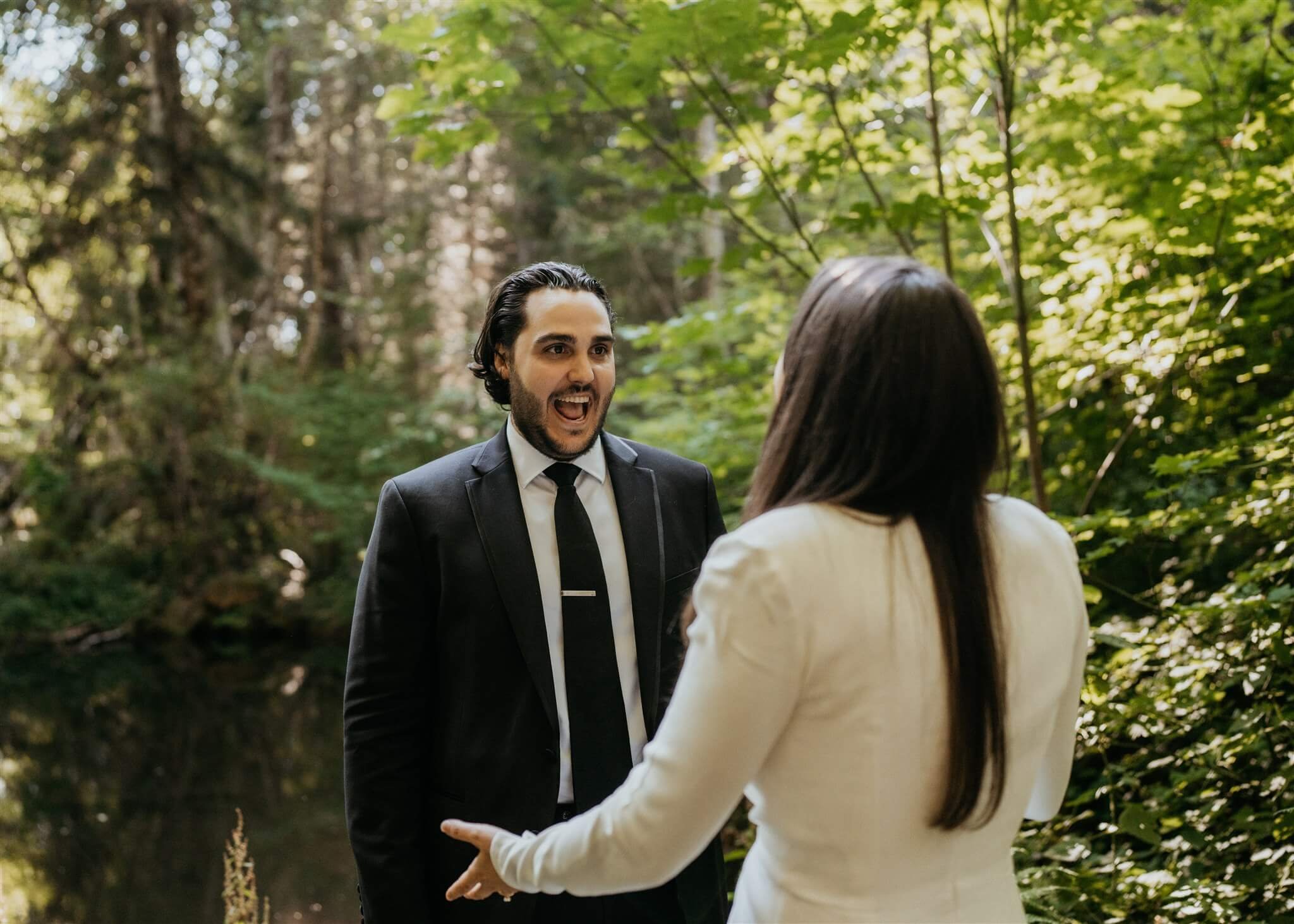 Groom reacts during wedding first look in the forest at Wellspring Spa