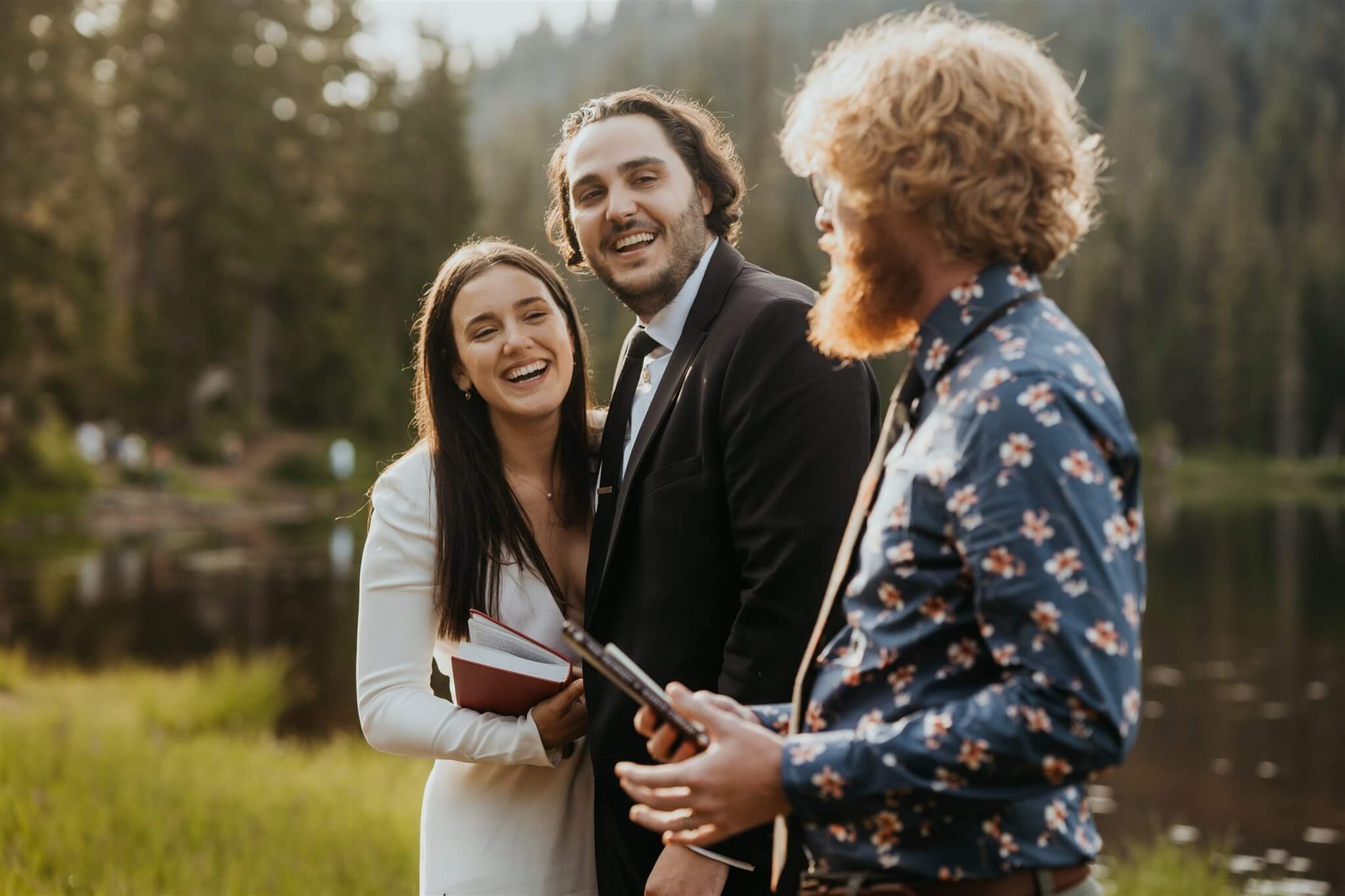 Bride and groom laugh while officiant speaks at outdoor wedding ceremony at Mt Rainier