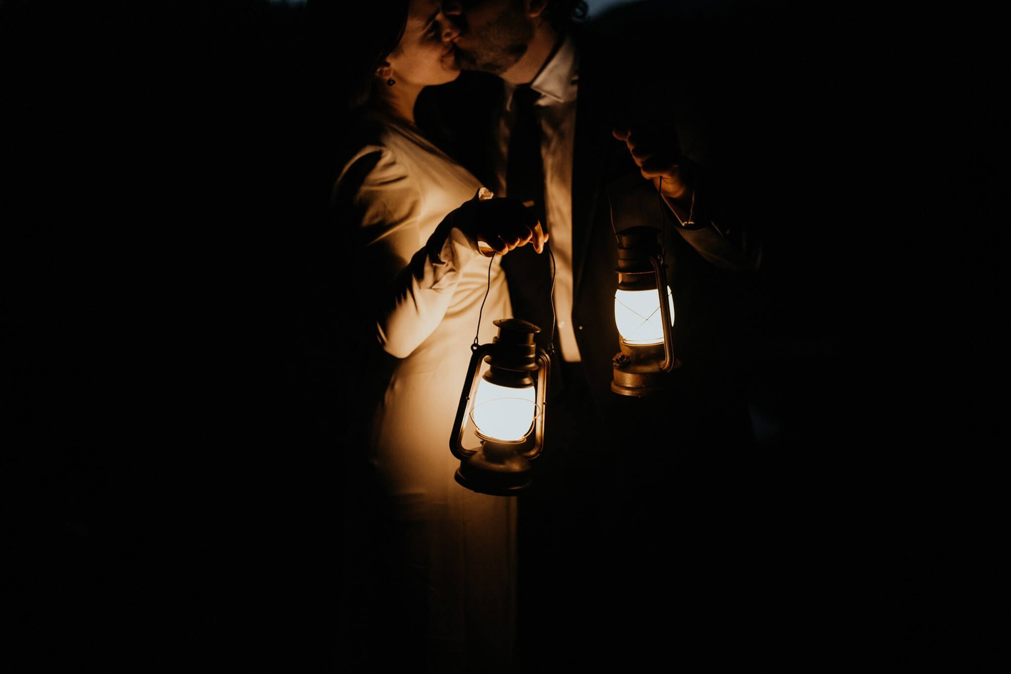 Bride and groom holding lanterns at dark during Mt Rainier adventure wedding