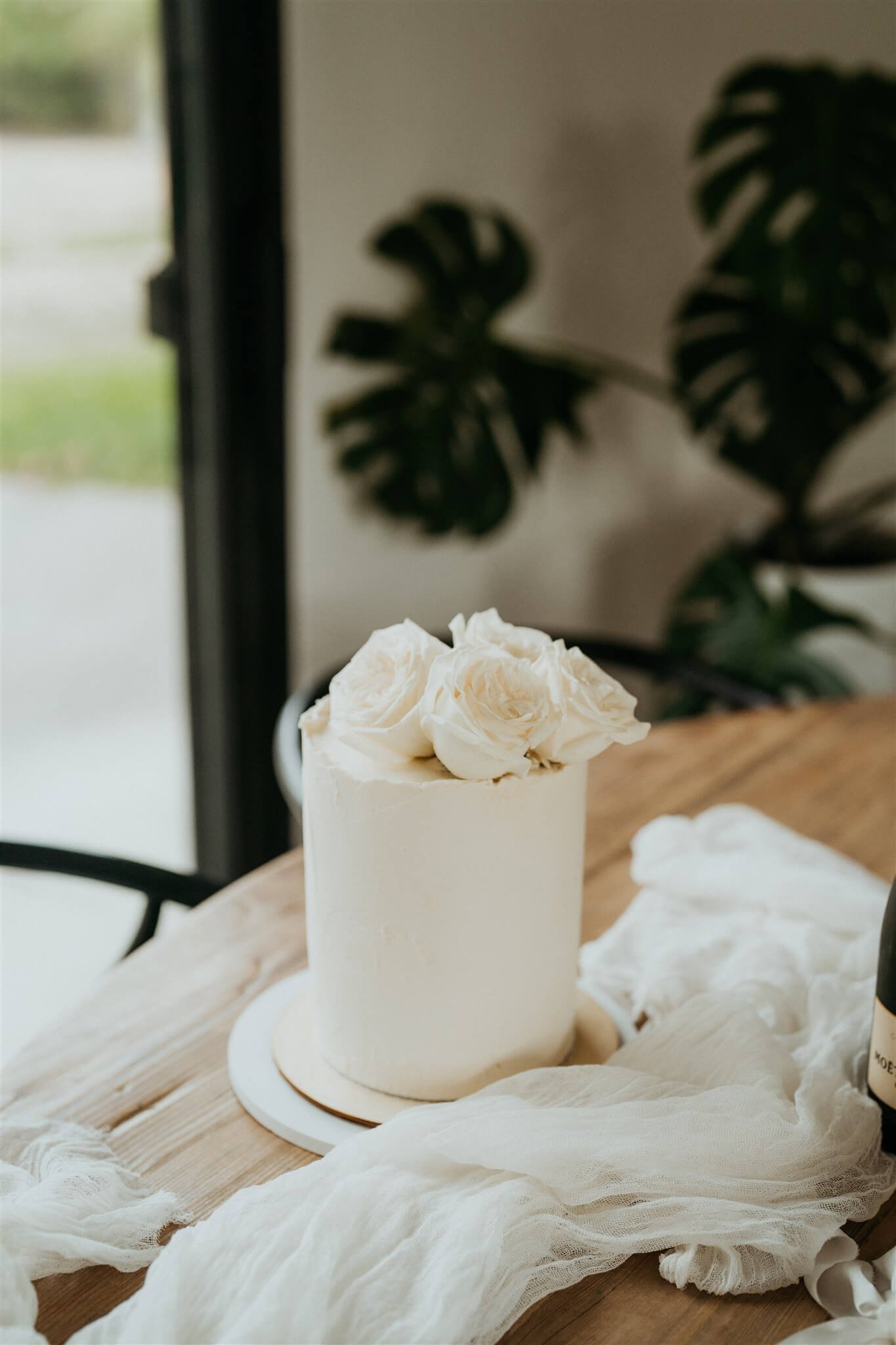 Minimal, modern white wedding cake topped with white flowers