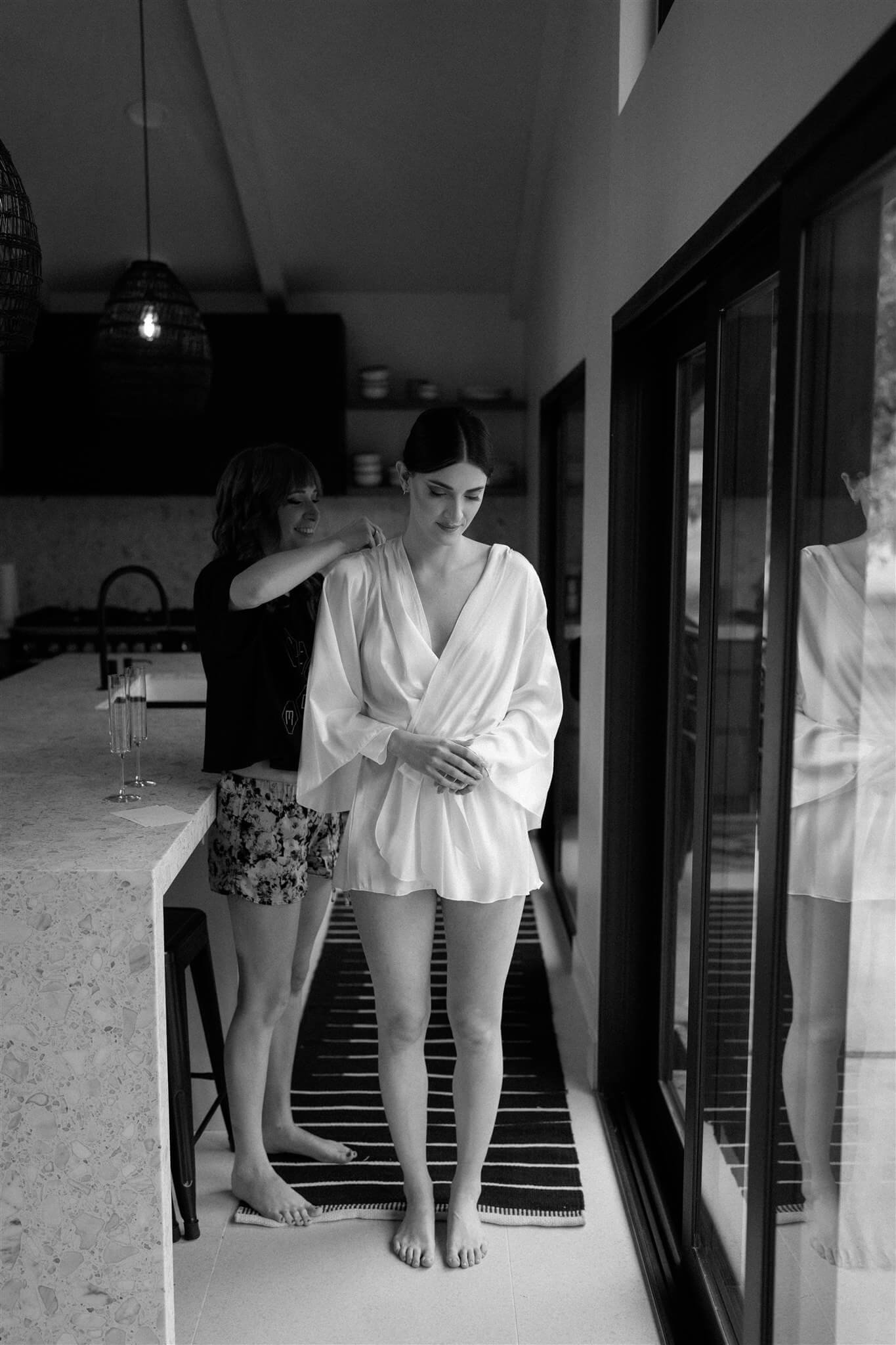 Bride wearing white robe getting ready for foggy Artist Point elopement