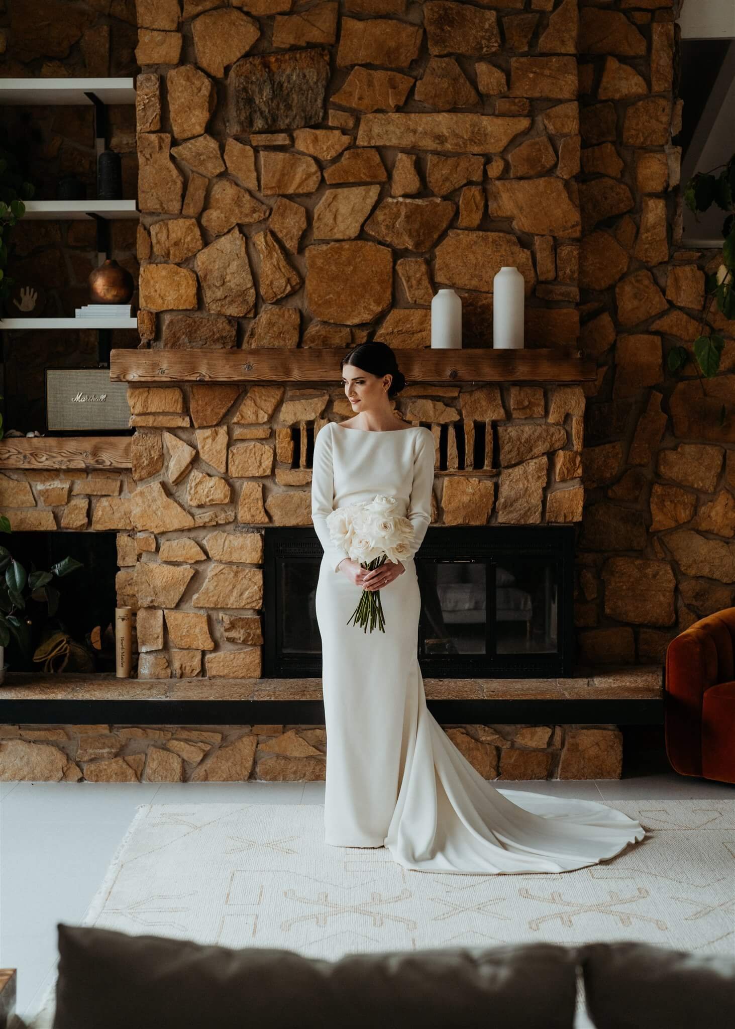 Bride portraits in front of stone fireplace at Airbnb cabin in the North Cascades