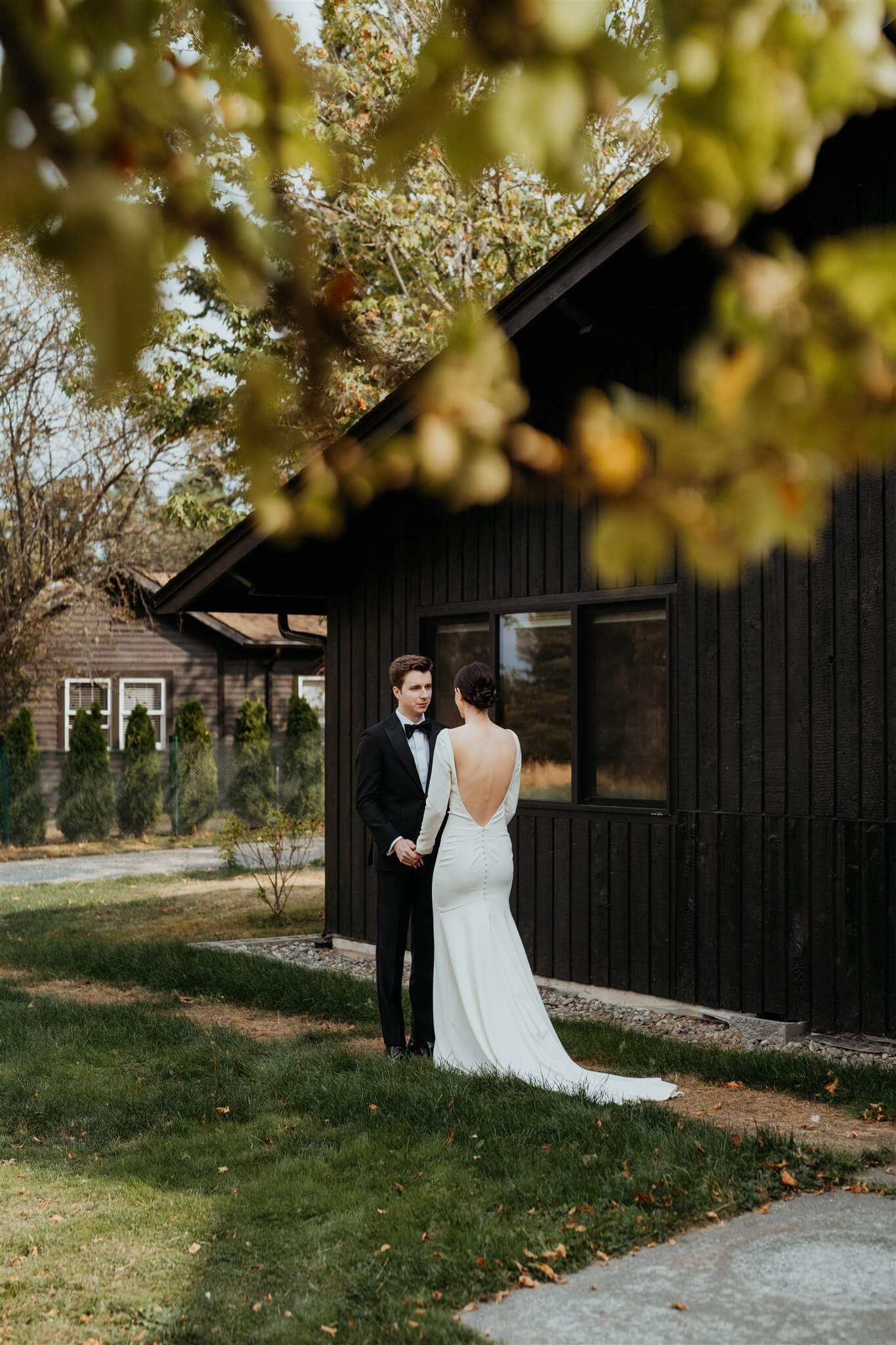 Bride and groom holding hands in front of their Airbnb cabin in the North Cascades