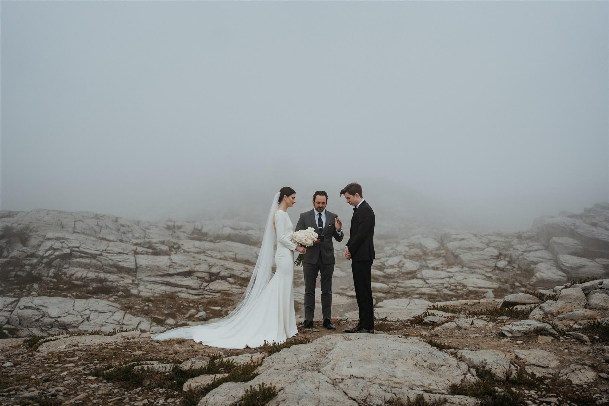 Bride and groom exchanging vows in the mountains at foggy Artist Point elopement