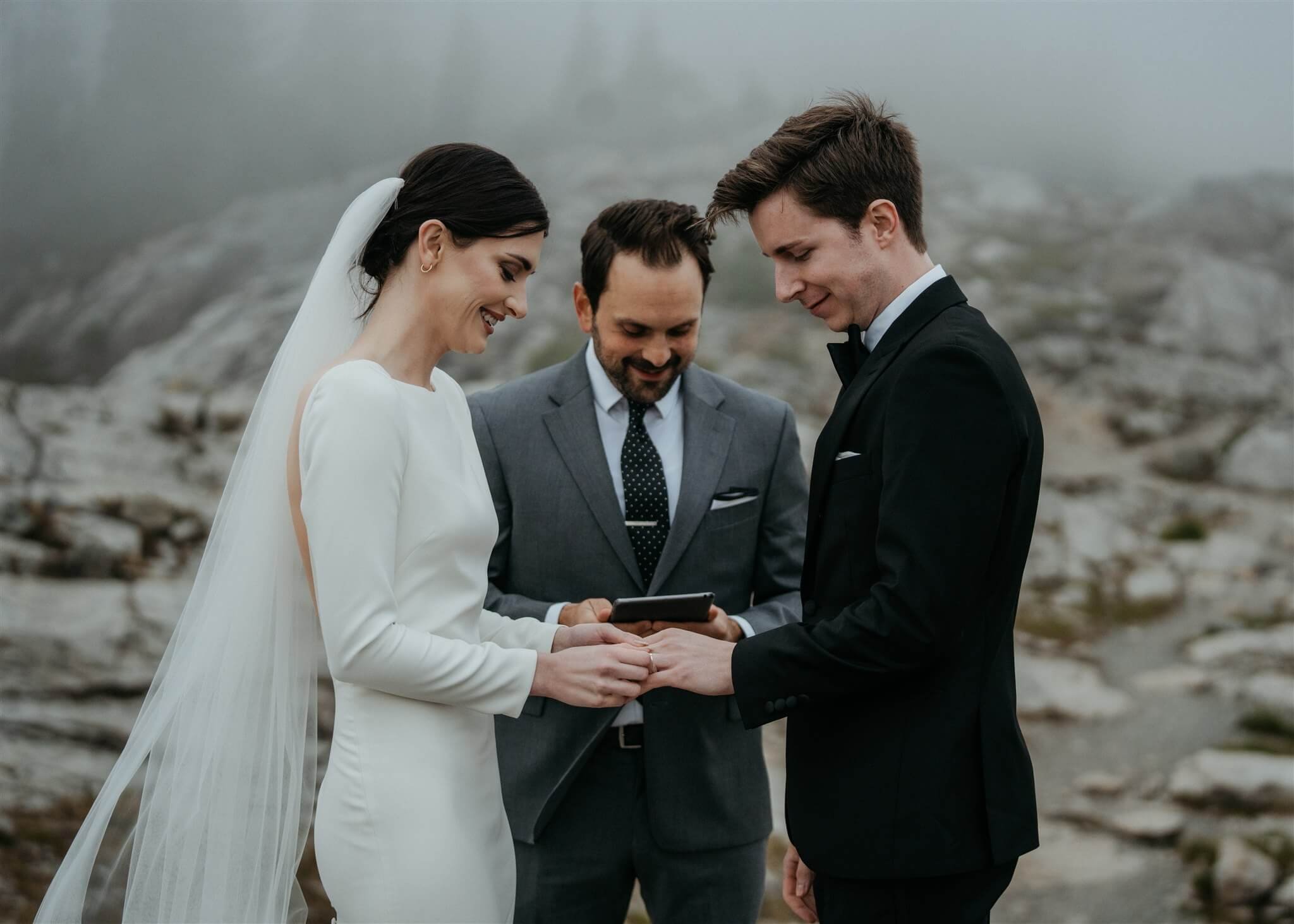 Bride and groom exchanging rings in the mountains at foggy Artist Point elopement