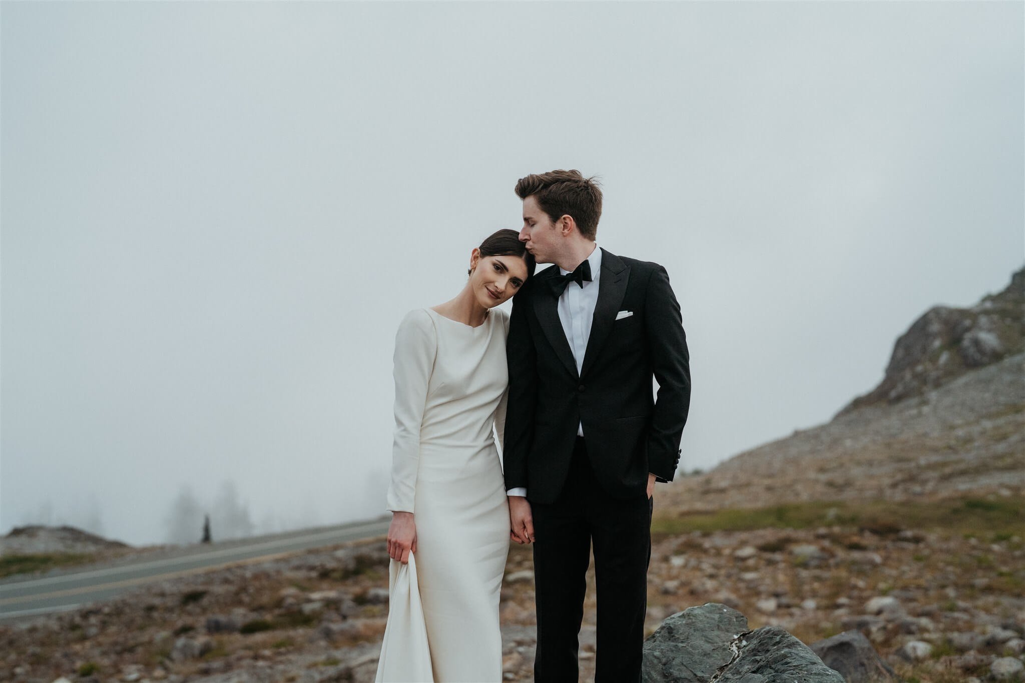 Bride rests head on groom's shoulder during foggy elopement in the North Cascades