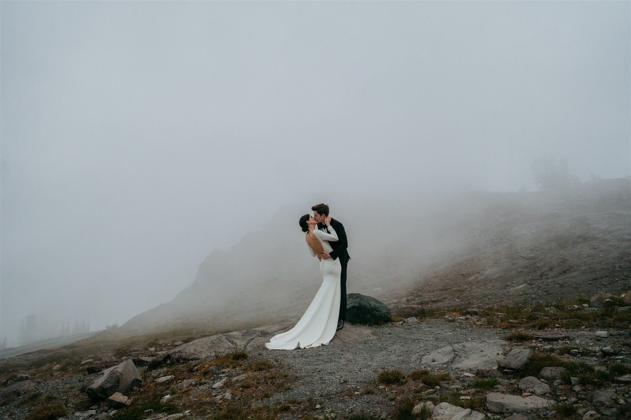 Bride and groom kiss in the foggy mountains at the North Cascades after their adventure elopement at Artist Point