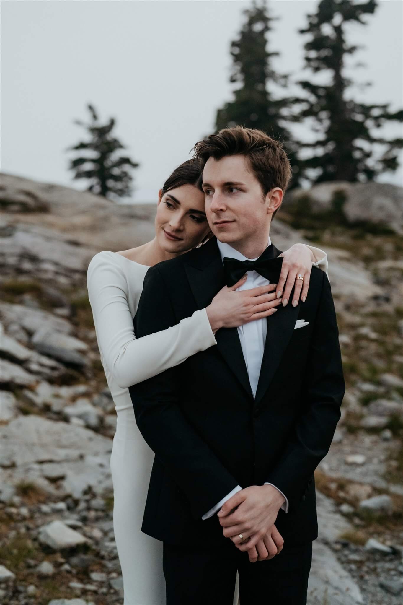 Bride wrapping arms around groom's neck during adventure portraits at Artist Point