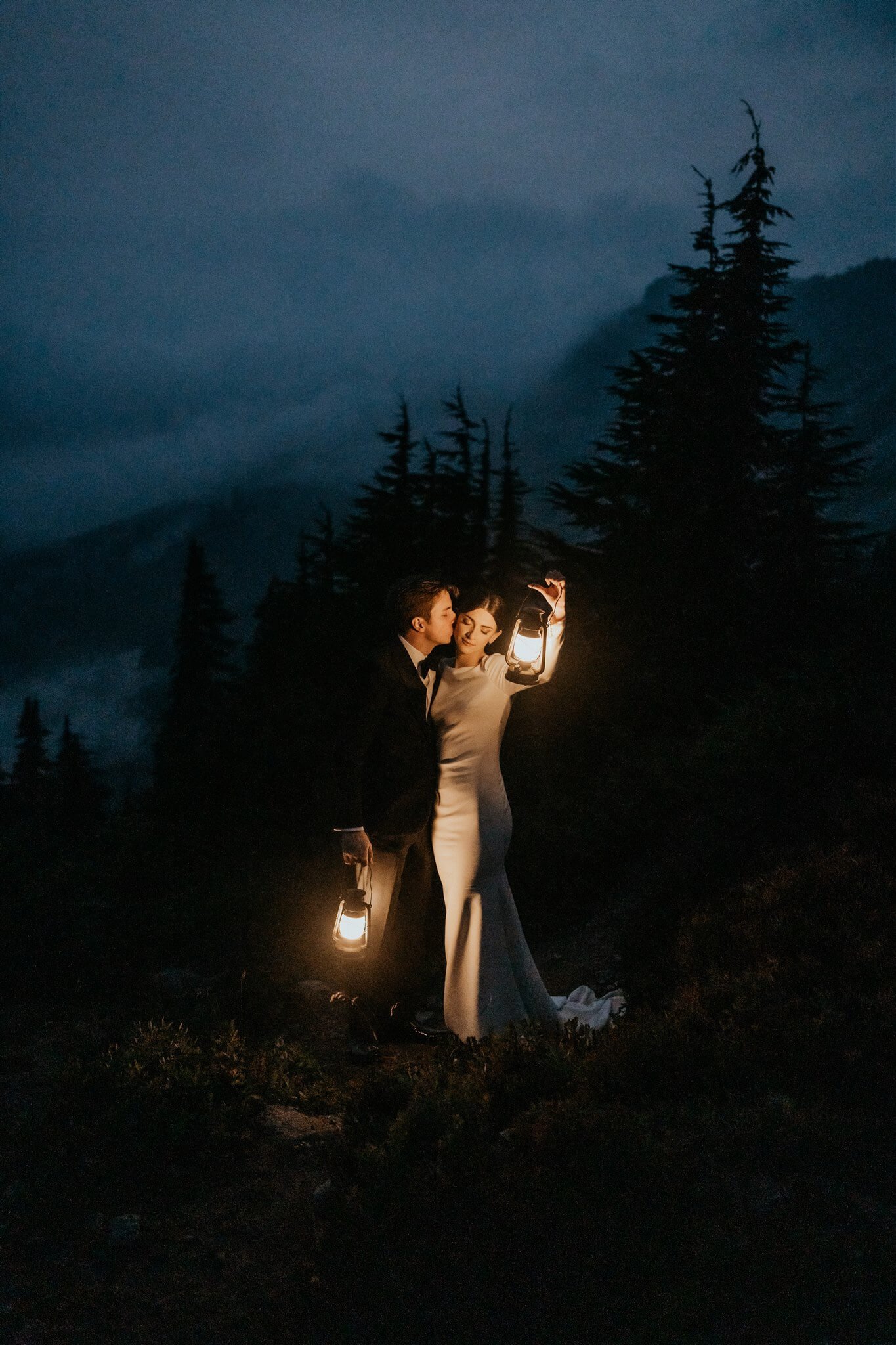 Bride and groom holding lanterns at the end of their foggy Artist Point elopement