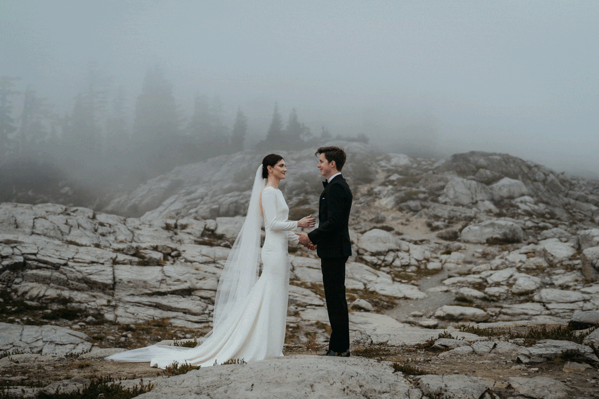 Bride and groom kiss at outdoor wedding ceremony at their foggy Artist Point elopement