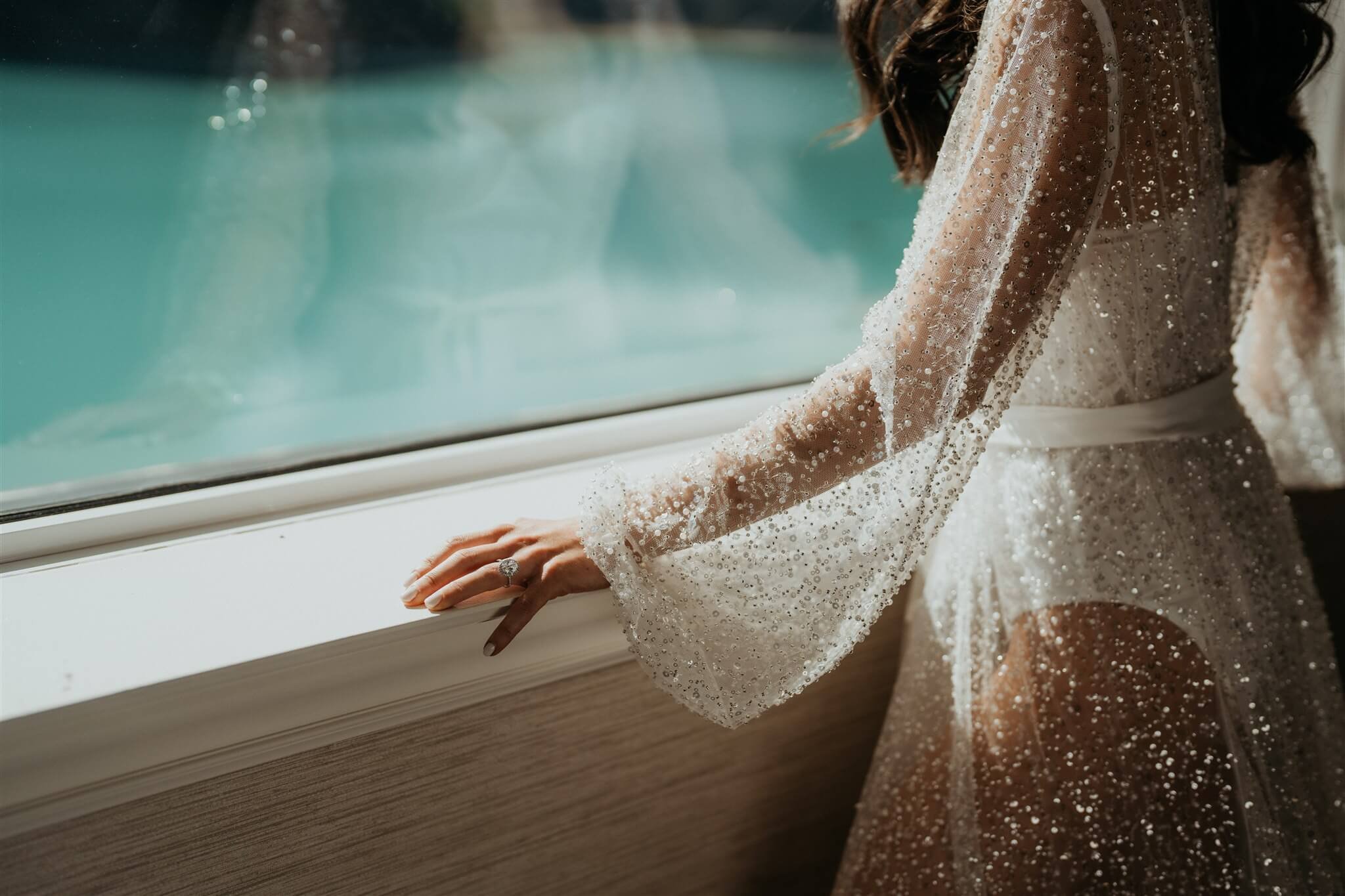 Bride wearing sheer sparkly robe while getting ready for Lake Louise wedding in Alberta, Canada