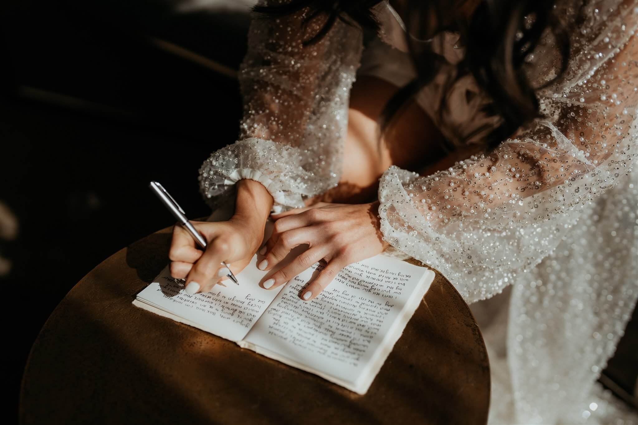 Bride writing vows while wearing sheer sparkly robe while getting ready for Lake Louise wedding in Alberta, Canada