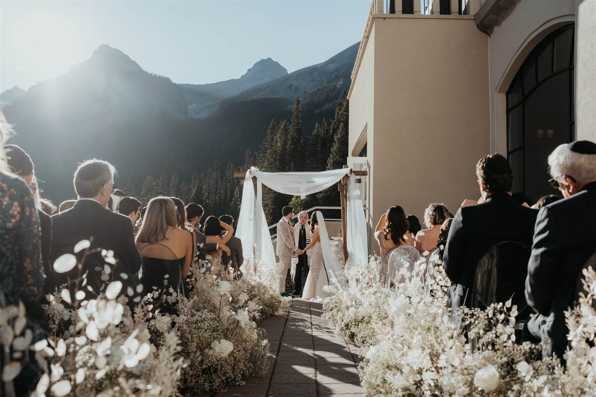Bride and groom standing at the altar at outdoor wedding ceremony by Lake Louise
