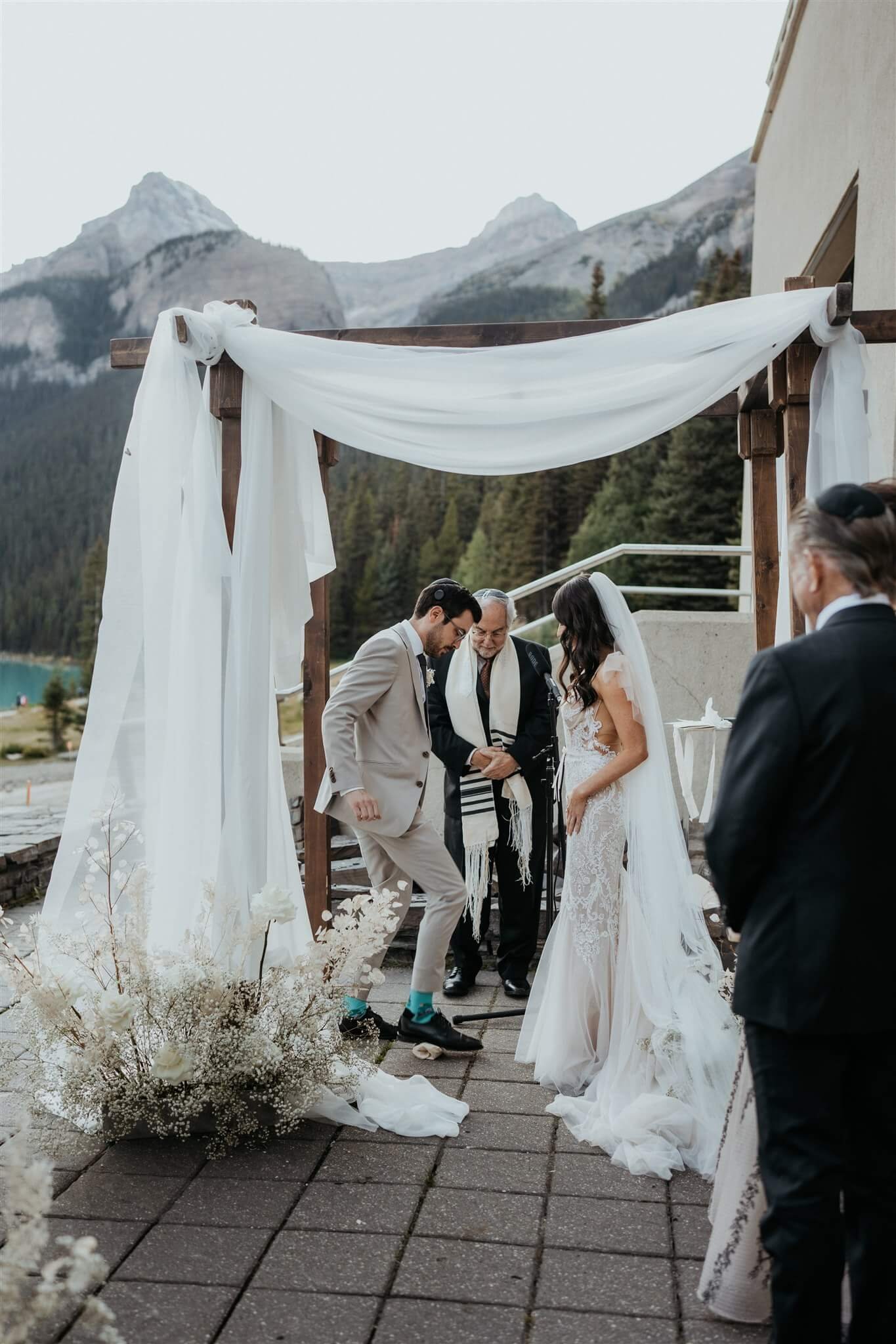Groom stomps on glass for Jewish wedding tradition at outdoor wedding ceremony