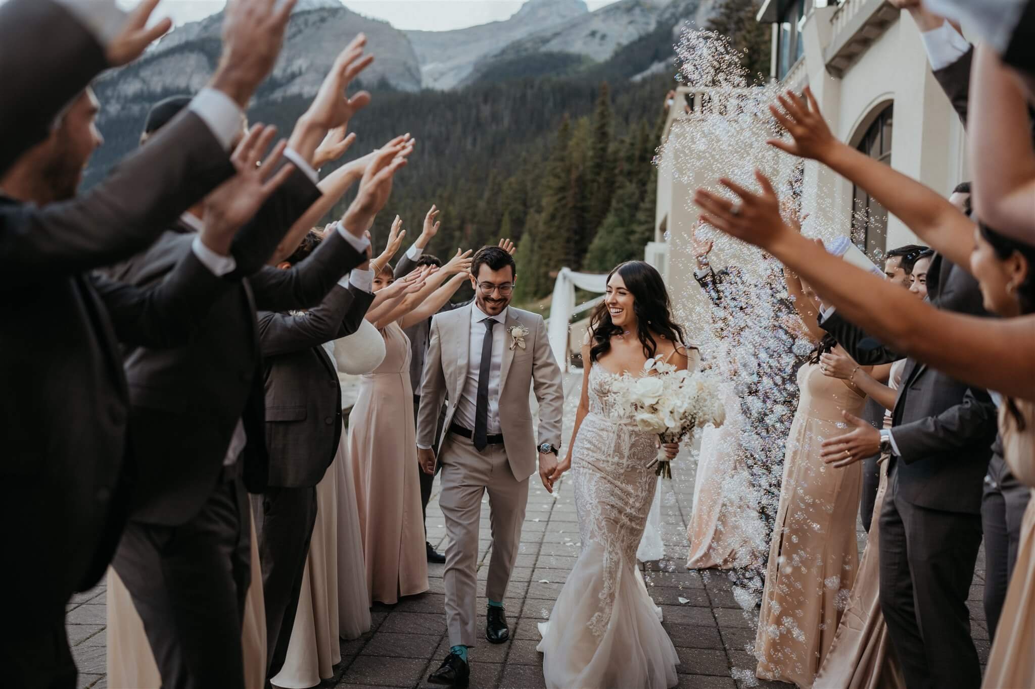 Bride and groom run through wedding party tunnel at Lake Louise wedding